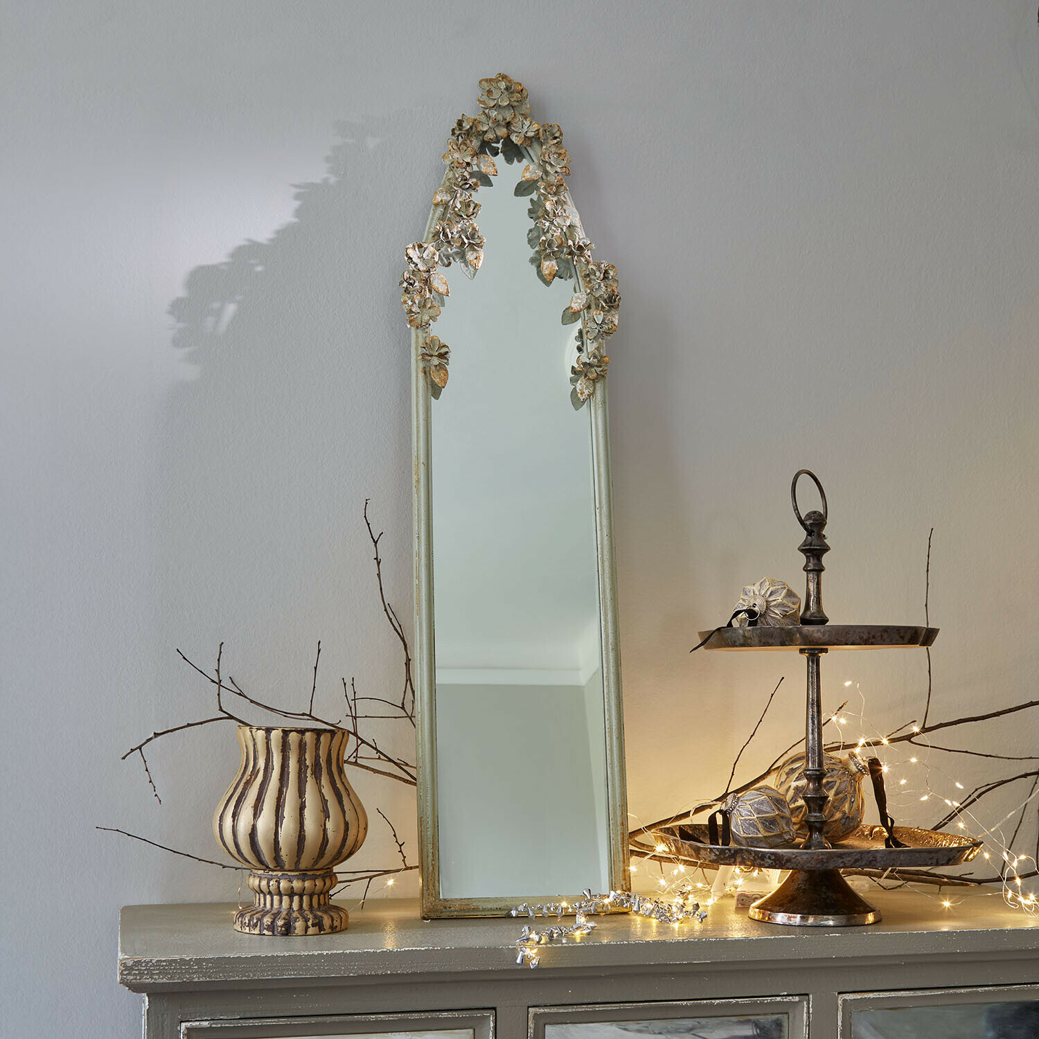 Specchio Clarendons Specchio stretto con cornice dorata antica e decorazioni floreali su mobile con luci decorative