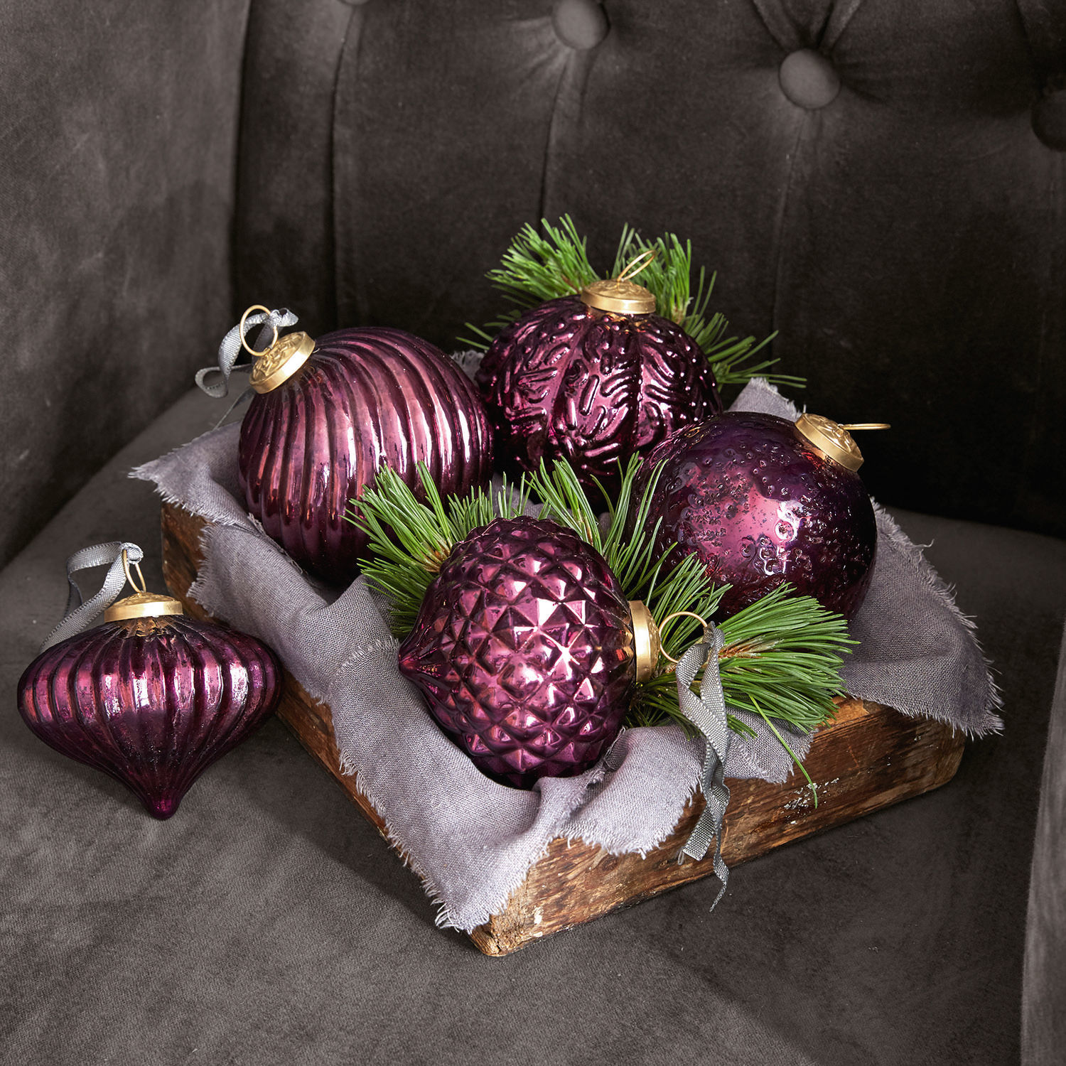 Set di 5 decorazioni natalizie Sambre Set di palline di Natale in vetro viola con rami verdi in cassetta di legno su sfondo grigio