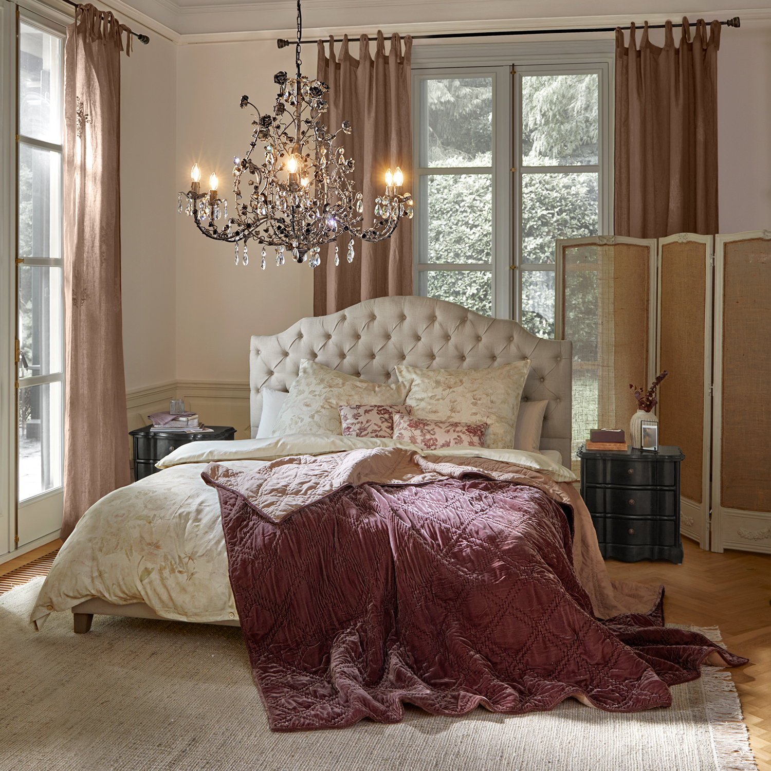 Camera da letto accogliente con testiera imbottita beige e coperta in velluto bordeaux sul letto