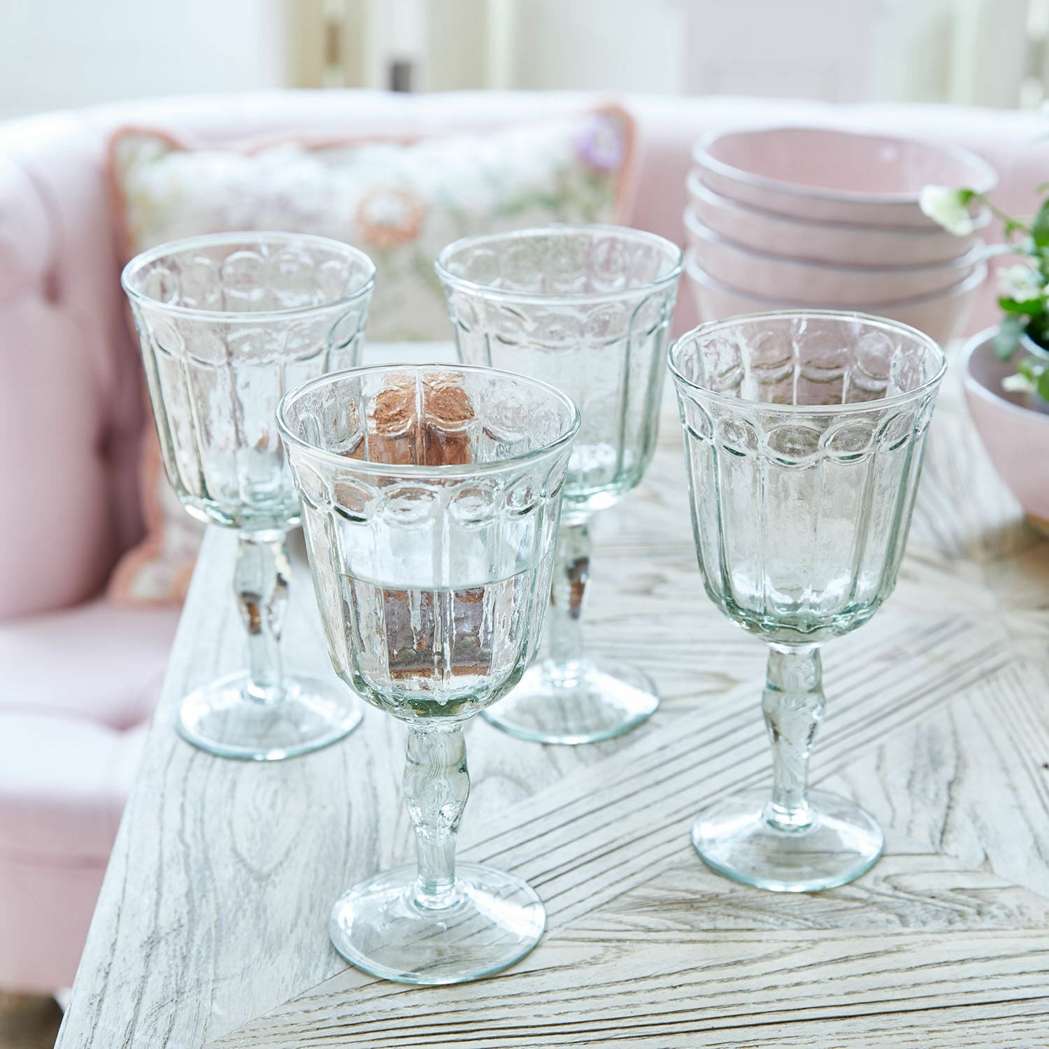 Set di 4 bicchieri Jolielle Set di quattro bicchieri trasparenti con motivo decorativo su tavolo in legno chiaro