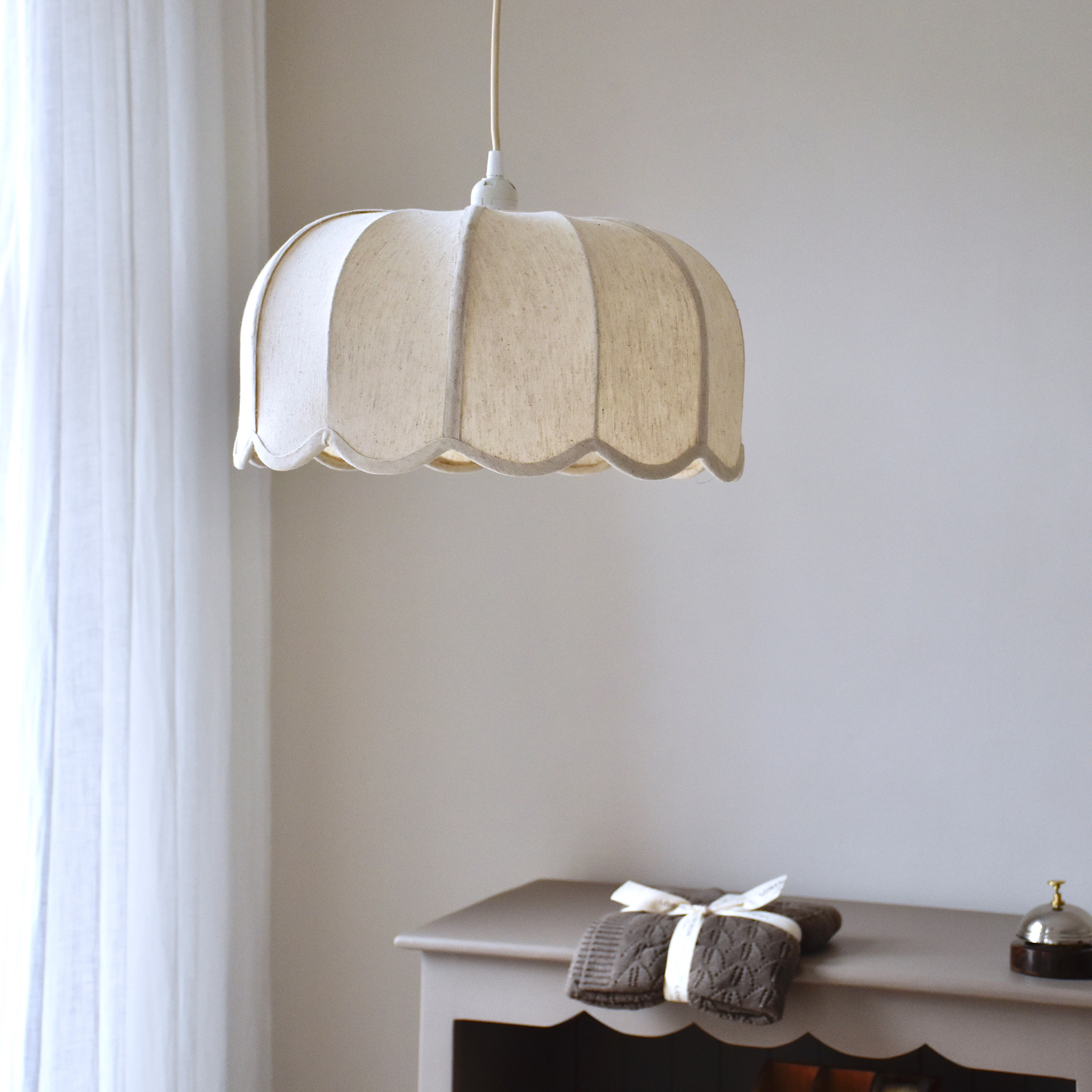 Lampada a sospensione in tessuto color crema con forma ondulata, luce soffusa per interni