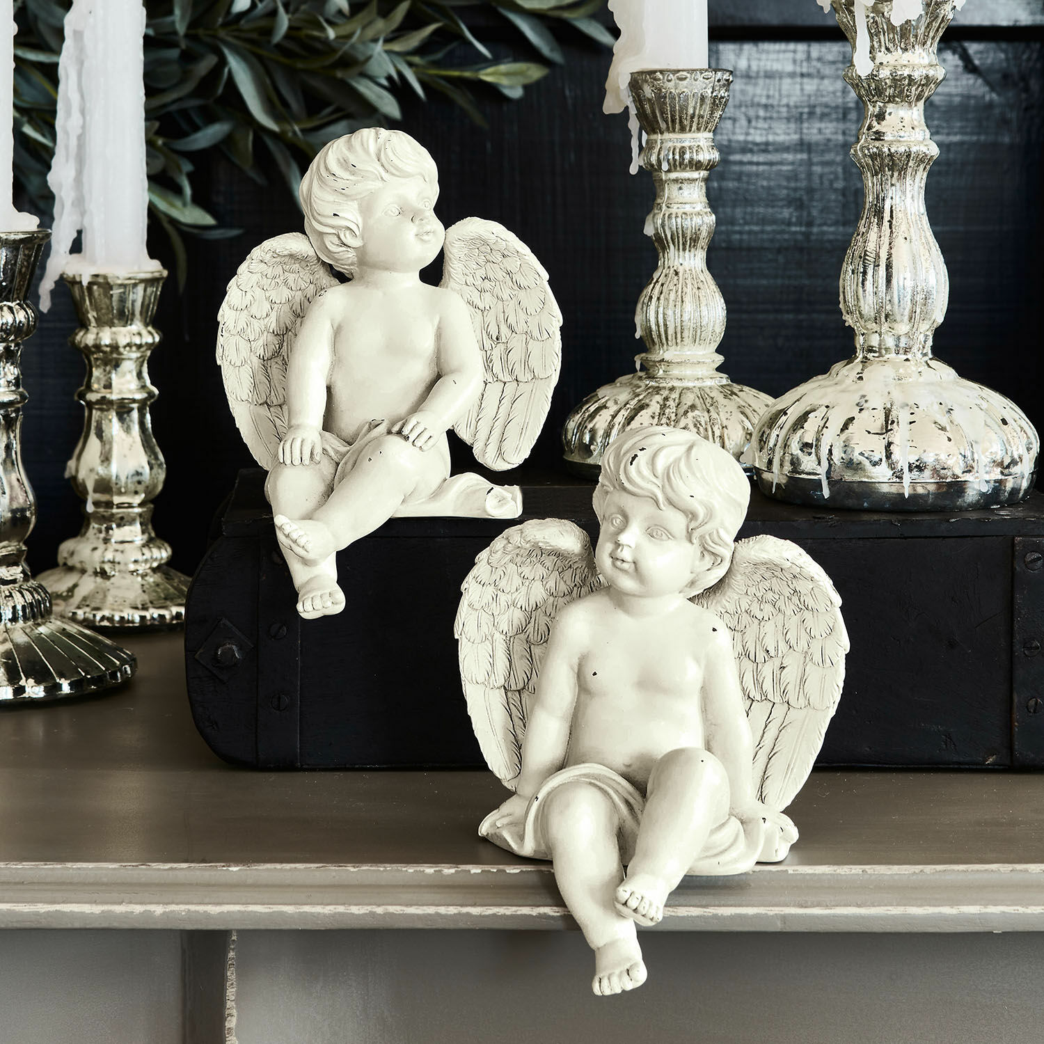 Coppia di angioletti decorativi Starlight Due figure di angeli bianchi in resina davanti a candelabri decorativi argentati