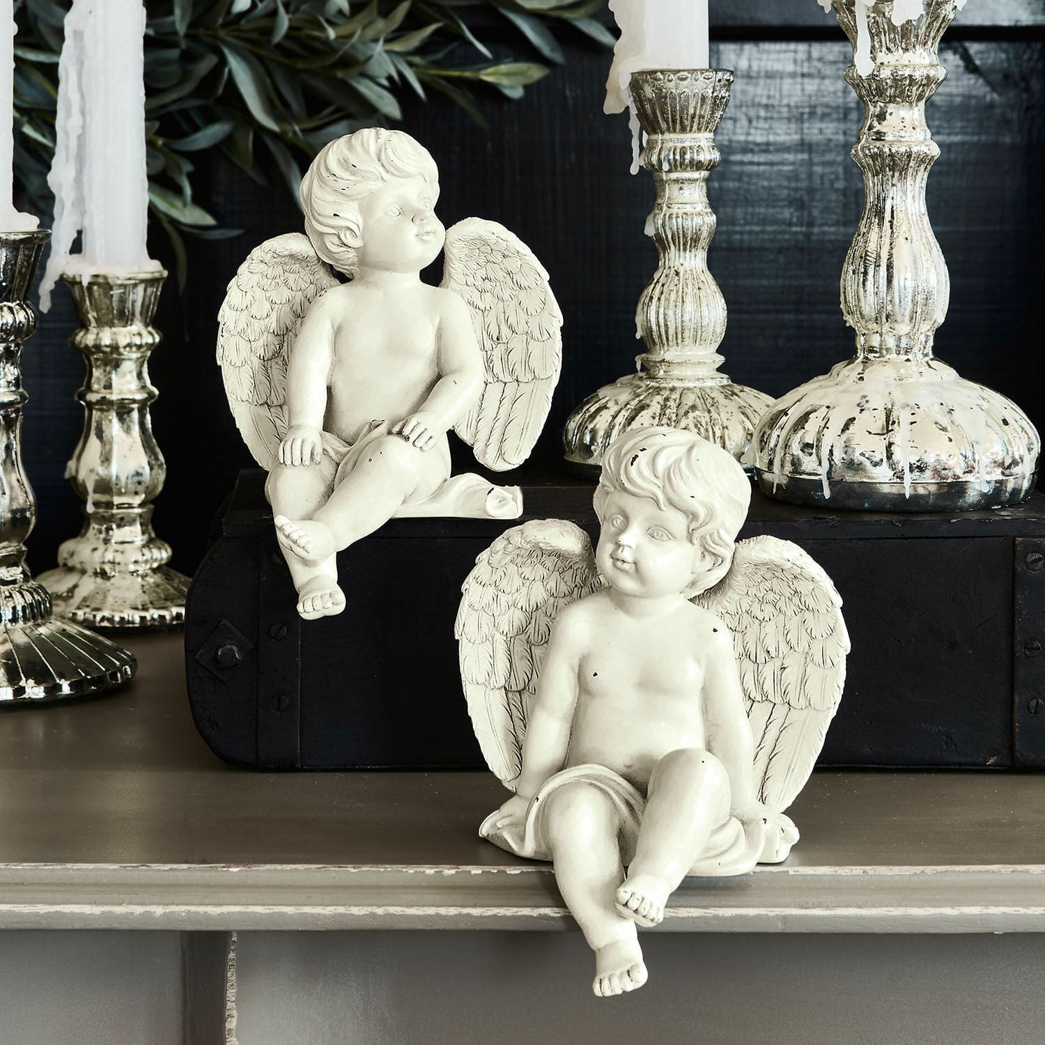 Coppia di angioletti decorativi Starlight Due figure di angeli bianchi in resina davanti a candelabri decorativi argentati