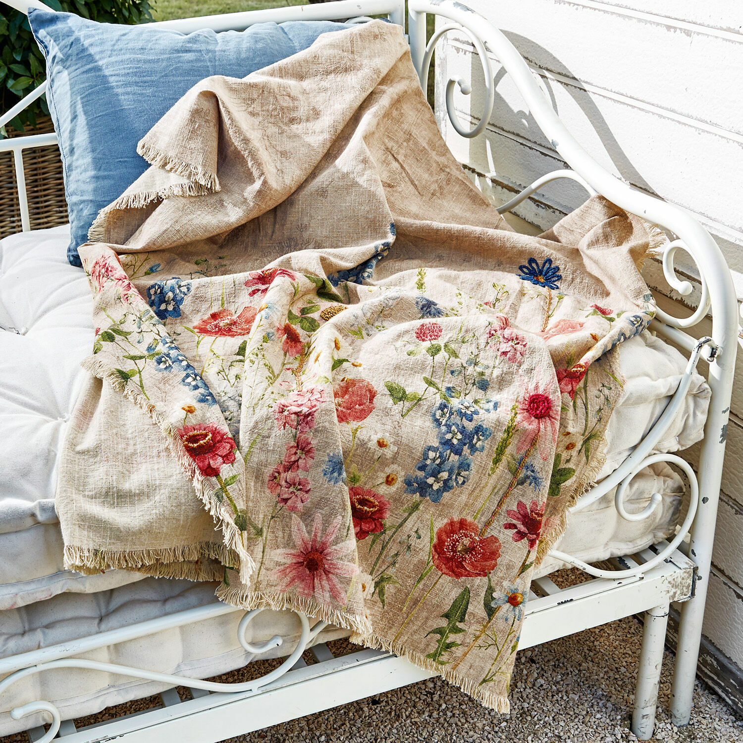 Plaid Eleonoire Coperta beige in lino con motivo floreale colorato e frange su panca metallica bianca