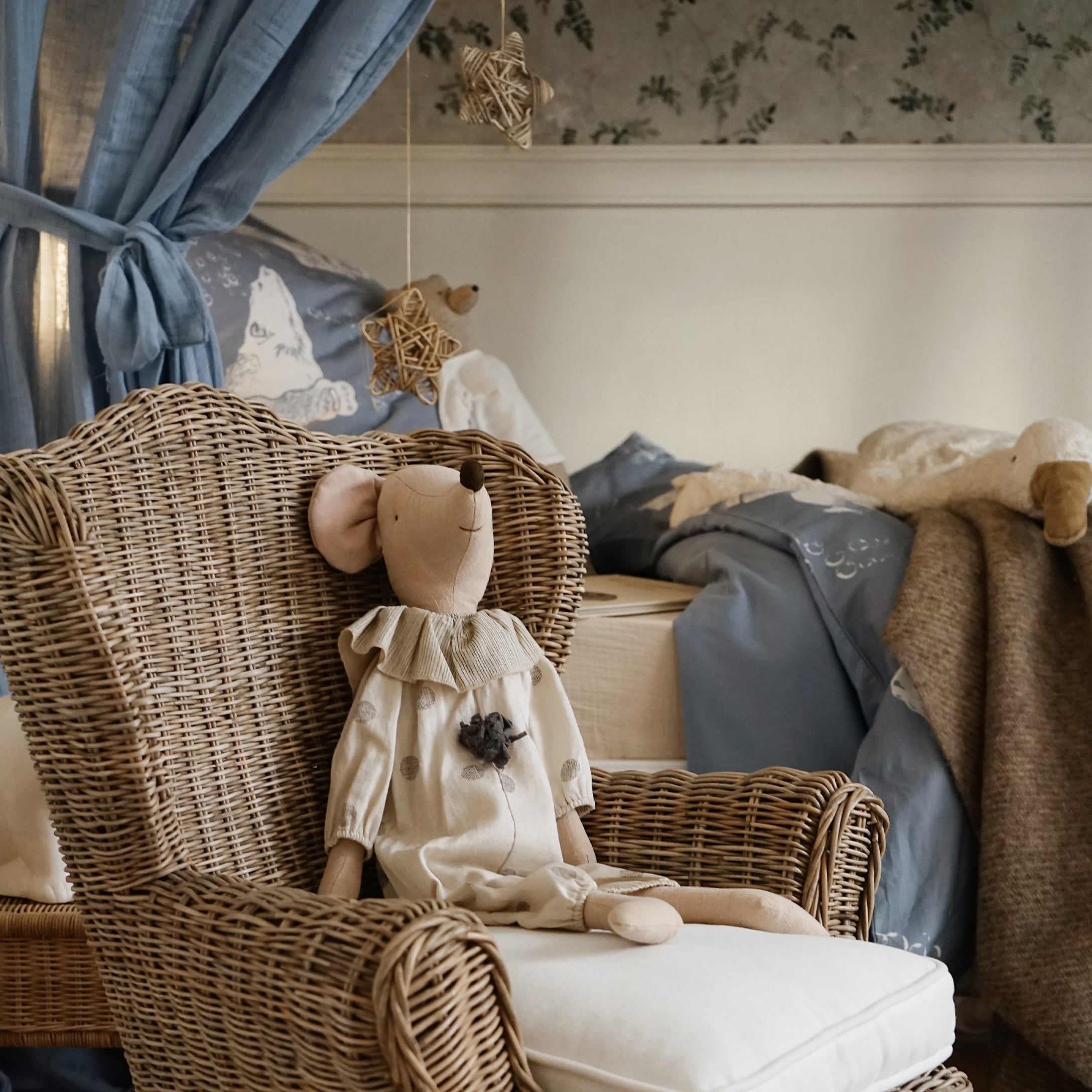 Camera bambini naturale con poltrona in vimini e topo di peluche beige con vestito
