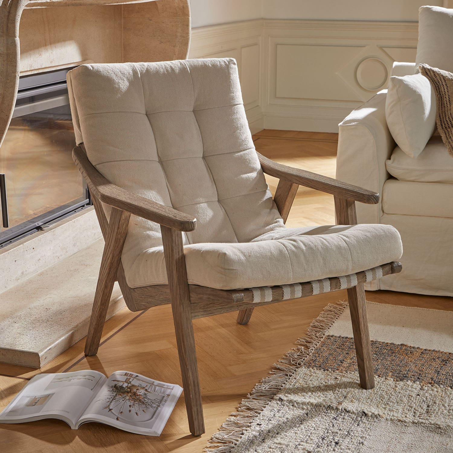Poltrona con tessuto beige chiaro e struttura in legno naturale, ideale per il soggiorno