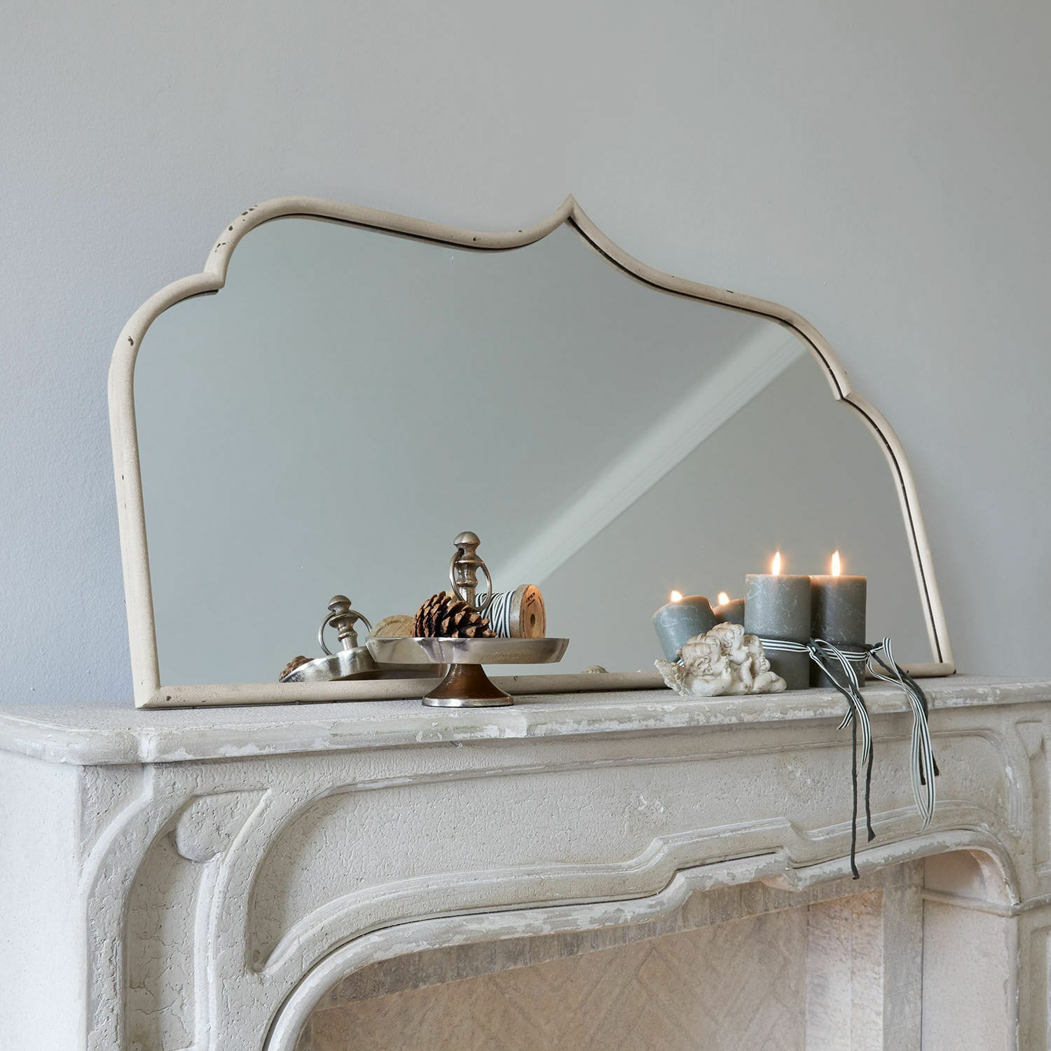 Specchio Selamira Specchio decorativo con cornice beige su camino in pietra con candele e pigne