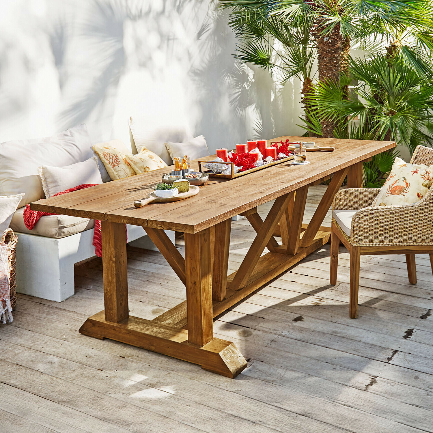 Tavolo Melvoro Grande tavolo da pranzo in legno di teak naturale su terrazza con candele rosse e snack decorativi