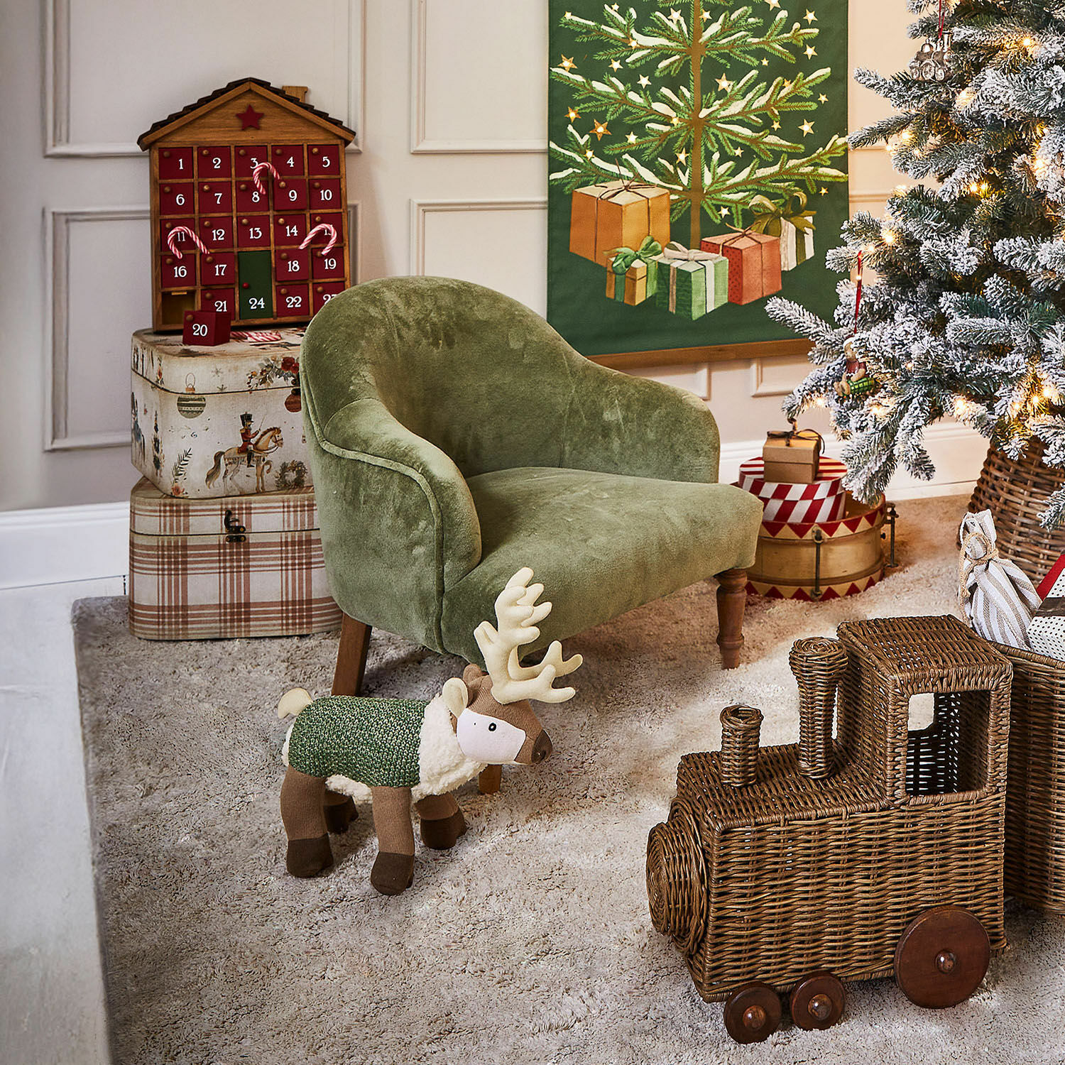 Poltrona per bambini Rowenna Poltroncina verde per bambini con renna di peluche e trenino in vimini in stanza decorata per Natale