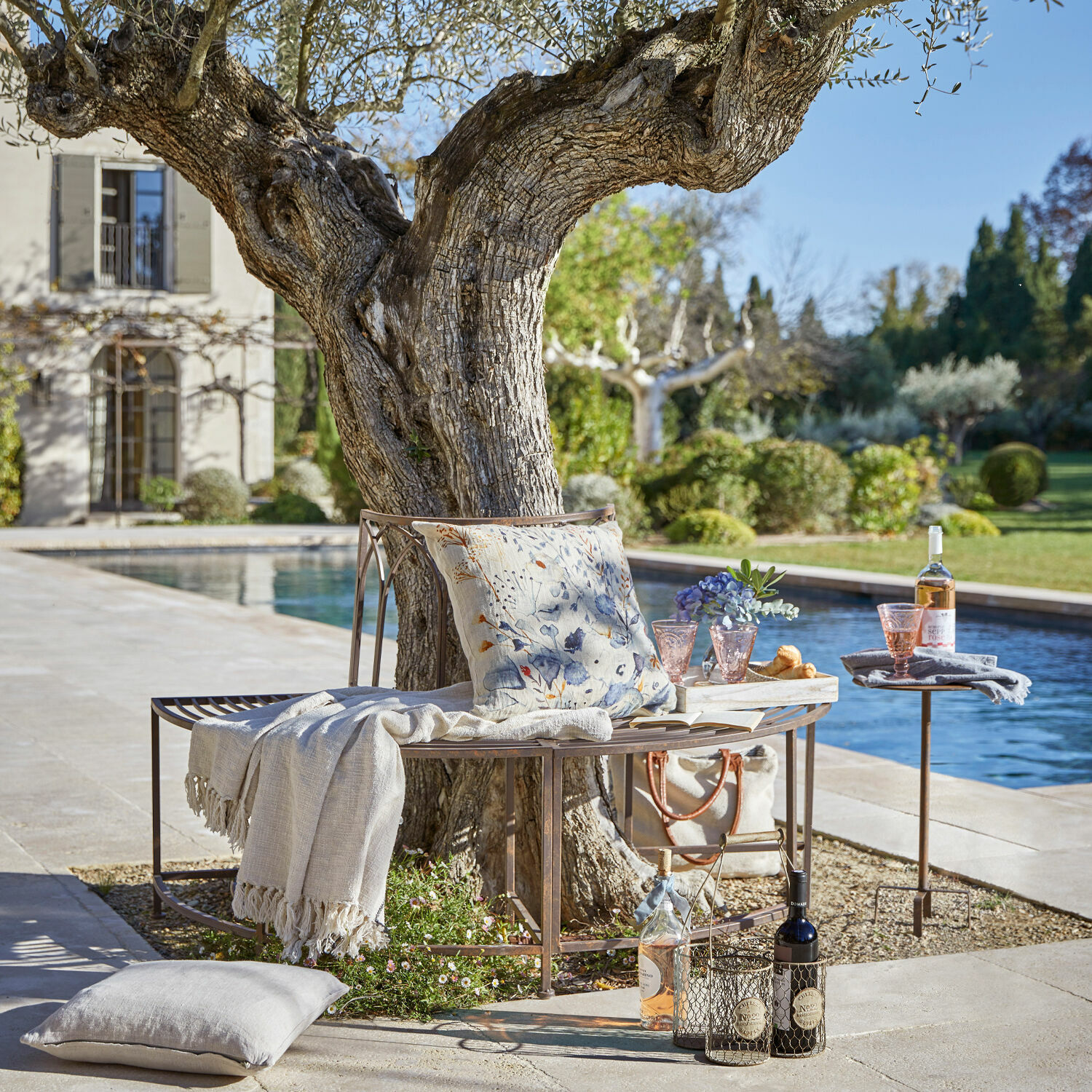 Panchina Sherburne Panchina in metallo intorno a un albero con cuscino e coperta vicino a piscina in giardino per relax all'aperto