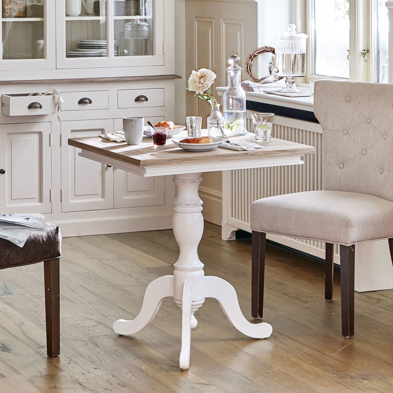 Tavolo Kingston Tavolo in legno bianco con gamba decorativa e piano in legno naturale in cucina luminosa