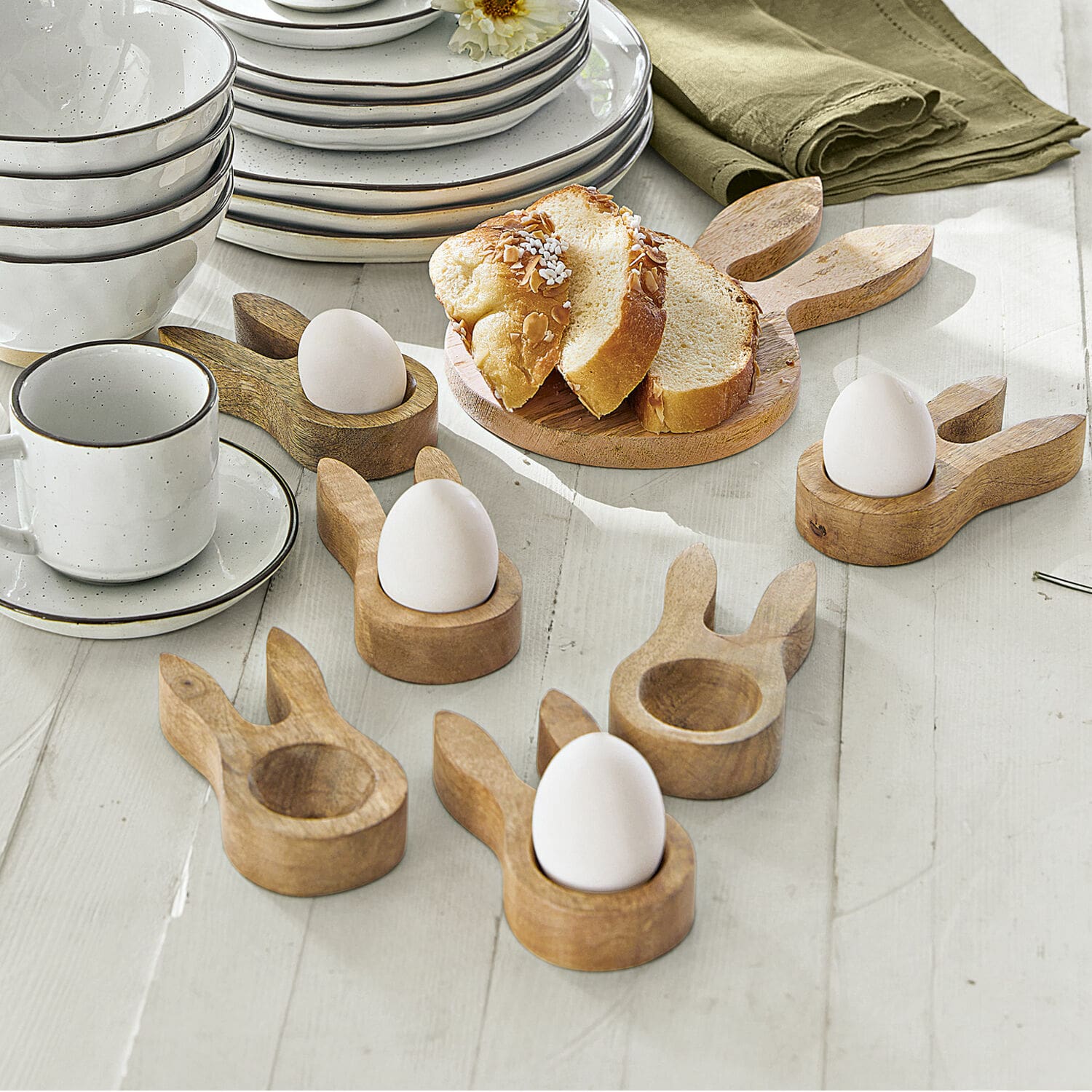 Set di 6 portauova Nante Portauova in legno a forma di orecchie di coniglio su tavolo chiaro con stoviglie bianche e pane