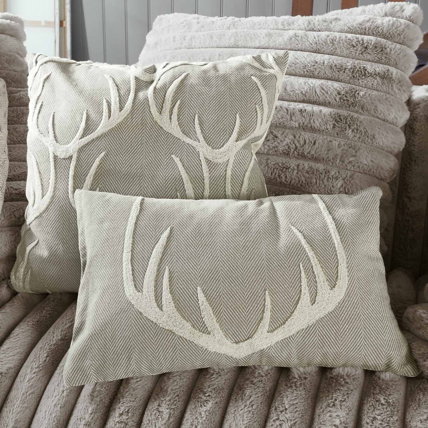 Cuscini beige con motivo corna su tessuto morbido, tessili decorativi per soggiorno accogliente