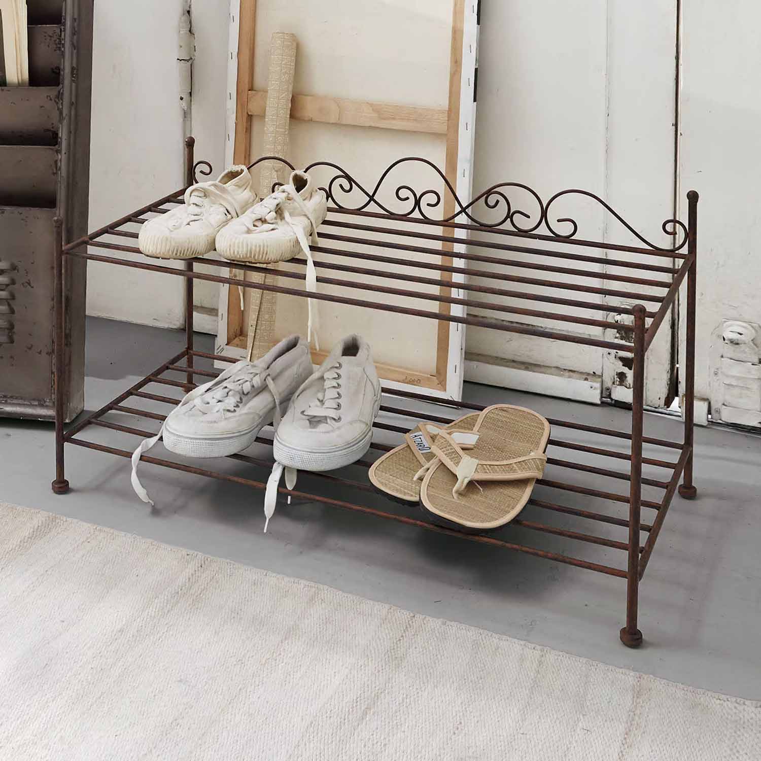 Scaffale porta scarpe in metallo arrugginito a due livelli con scarpe bianche e beige in stile vintage