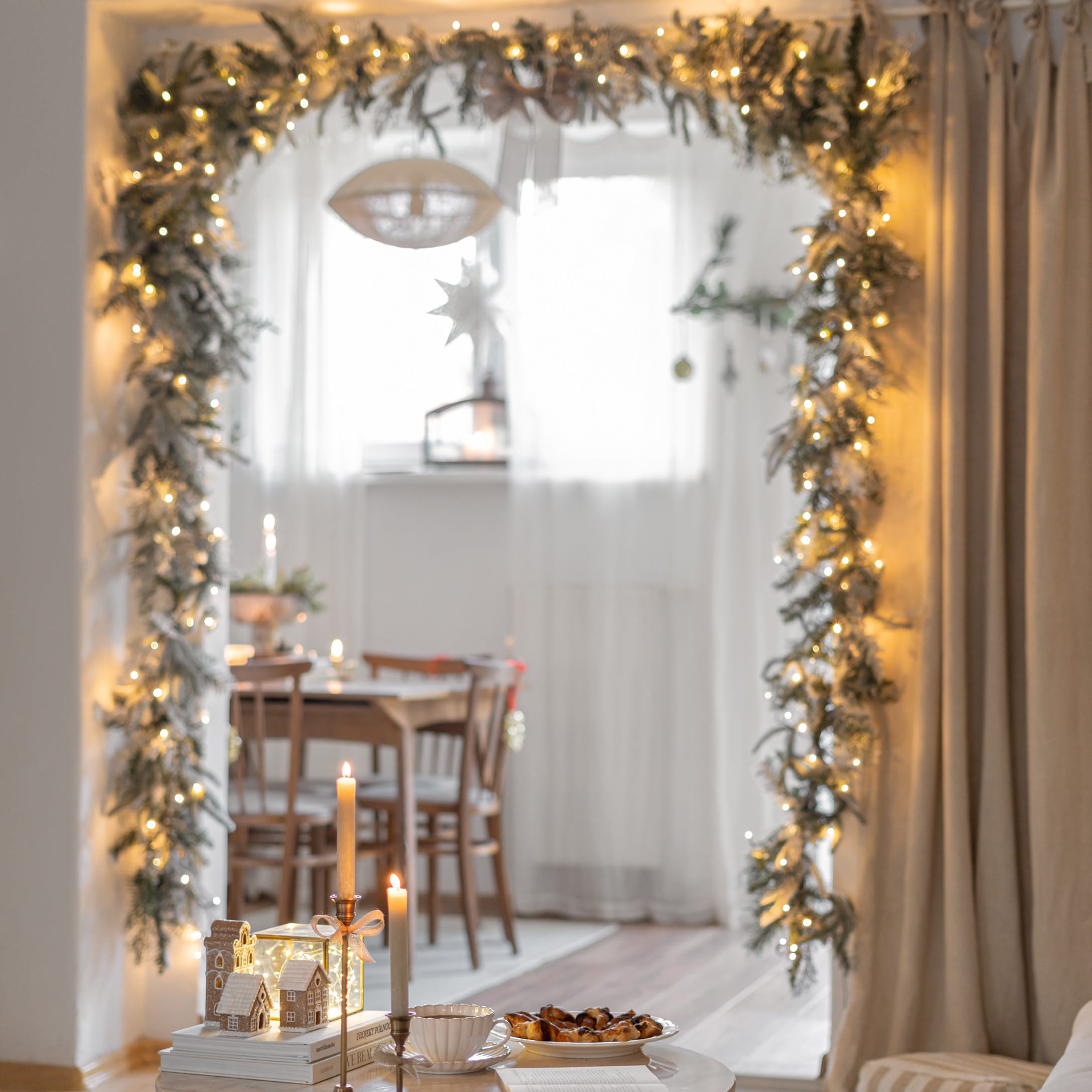 Decorazione natalizia con ghirlanda luminosa e candele in ambiente accogliente con tavolo in legno
