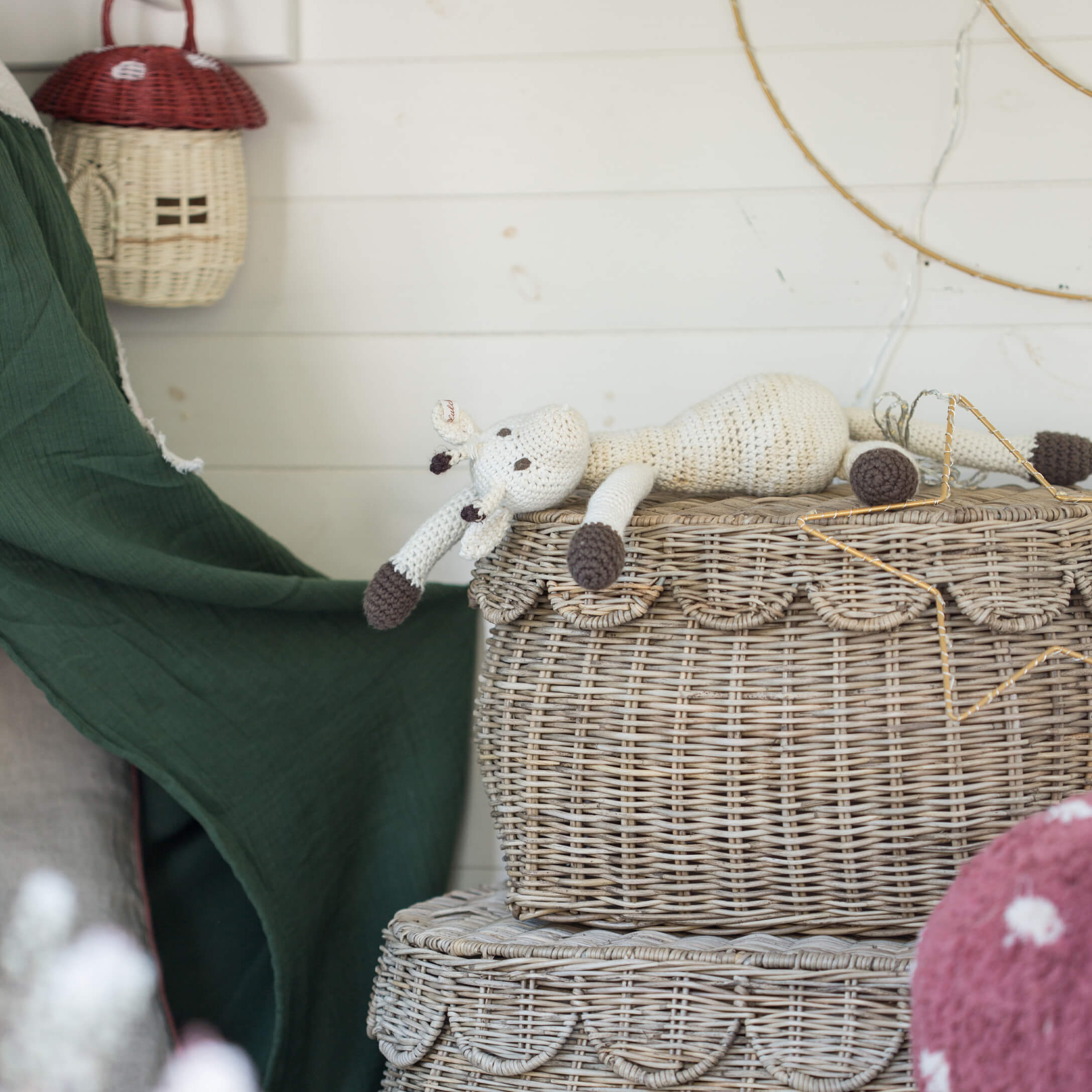 Giocattolo giraffa all'uncinetto bianco e marrone su cesto in vimini decorativo stile boho