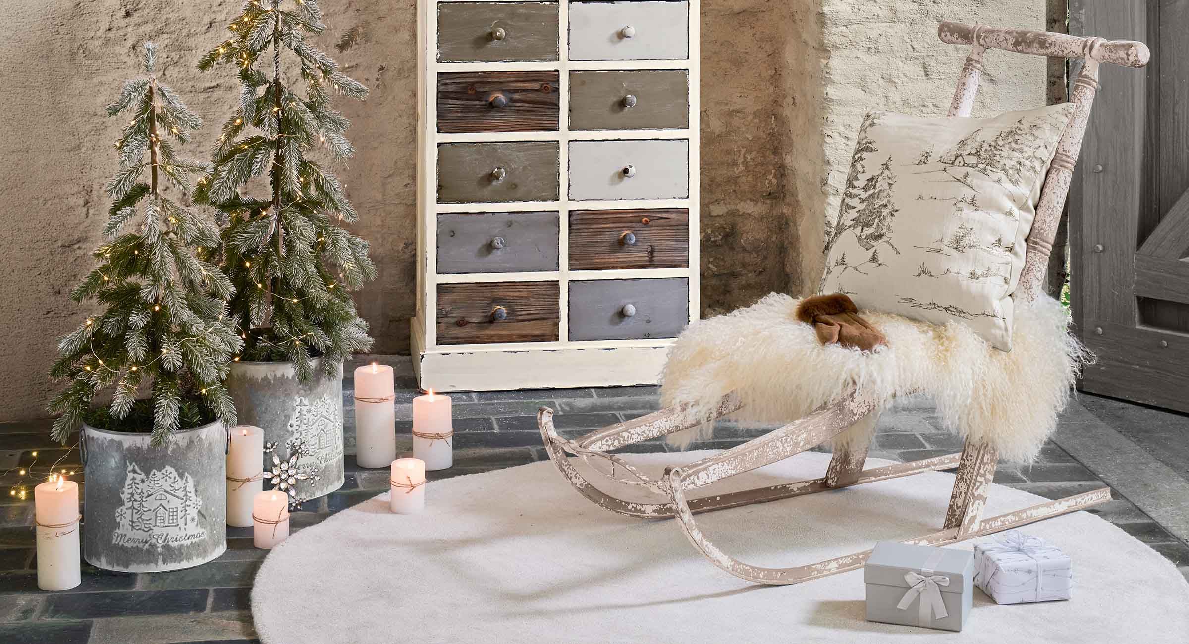 Slitta rustica in legno con pelliccia bianca e cuscino con motivo invernale in ambiente accogliente