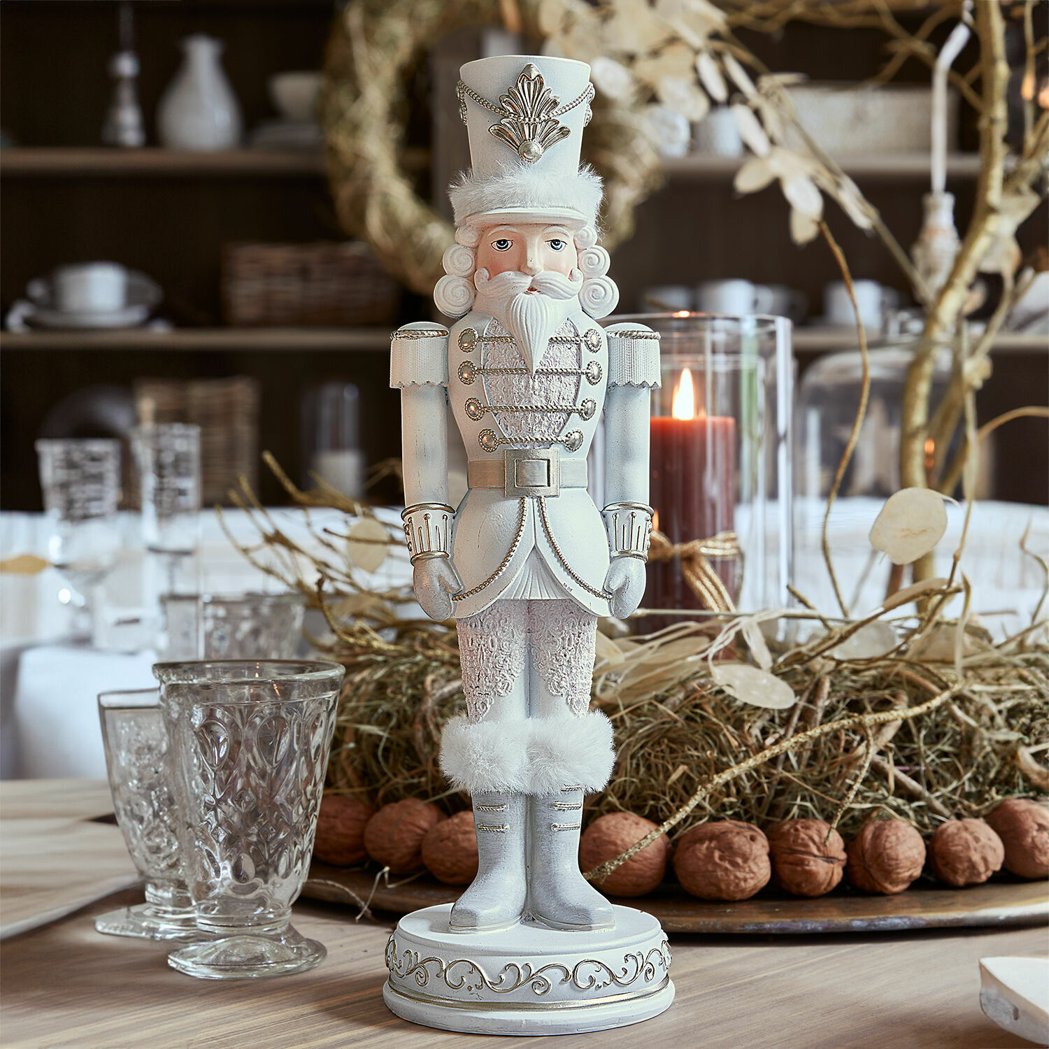 Schiaccianoci decorativo Moriette Schiaccianoci in legno bianco con dettagli in pelliccia e decorazioni argento su tavola natalizia