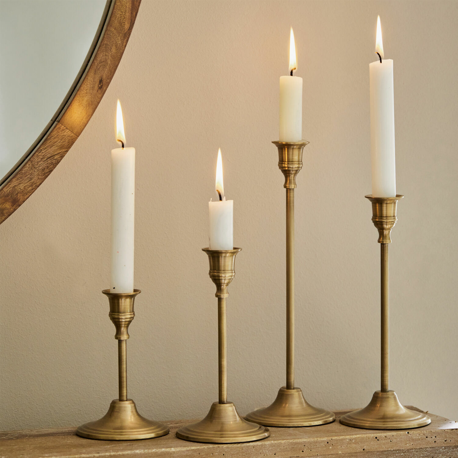 Set di 4 candelieri Namoris Set di quattro candelabri in ottone con candele bianche su superficie in legno, decorazione d'interni