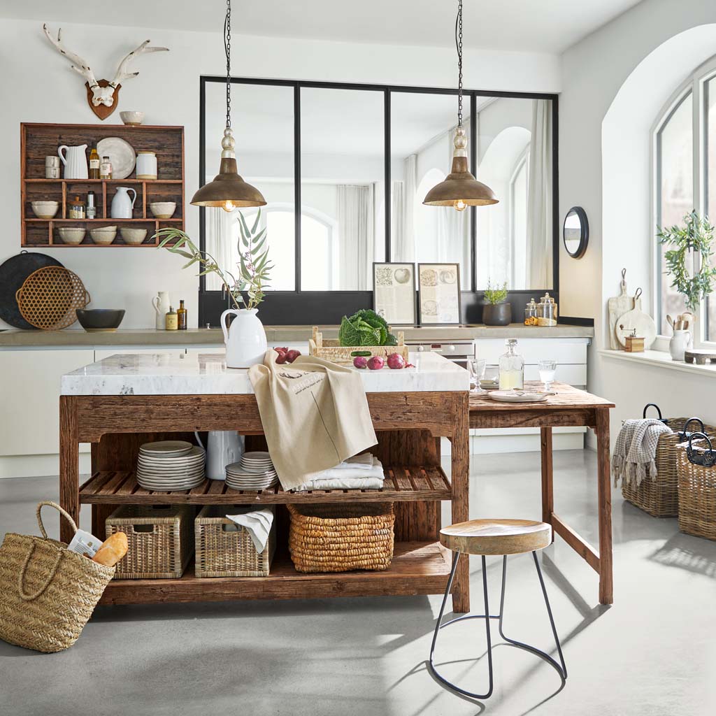 Cucina rustica con isola in legno e piano in marmo, cesti naturali e decorazioni