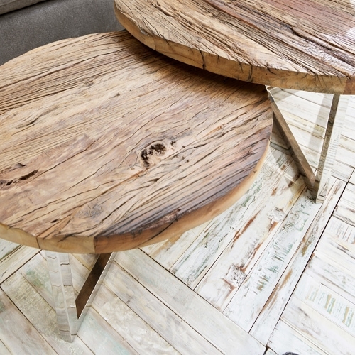 Due tavolini rotondi in legno naturale con gambe in metallo su pavimento chiaro, mobili moderni
