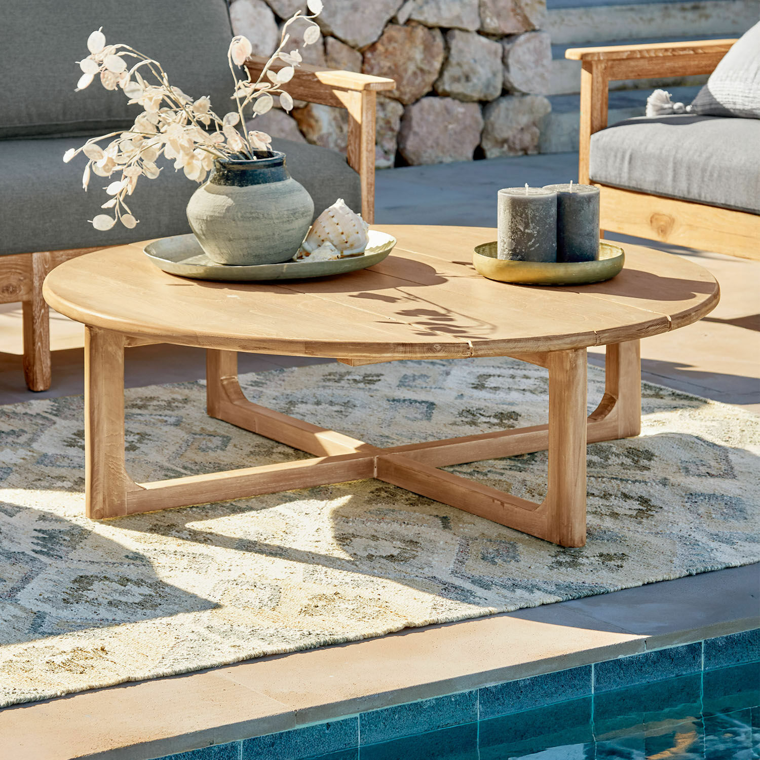 Tavolino da caffè Tewksbury Tavolino rotondo in legno di teak naturale su terrazza vicino alla piscina con decorazioni