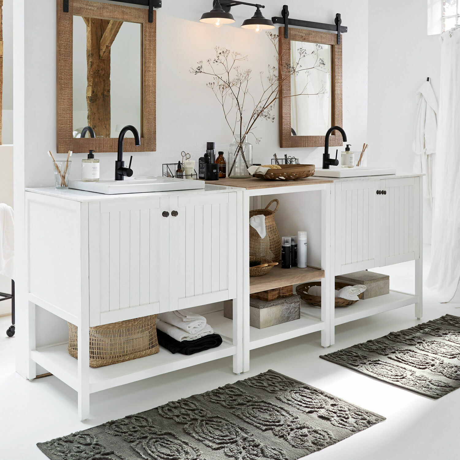 Mobile con lavabi Tandilje Mobile bagno bianco in legno con due lavandini e rubinetti neri, tappeti grigi