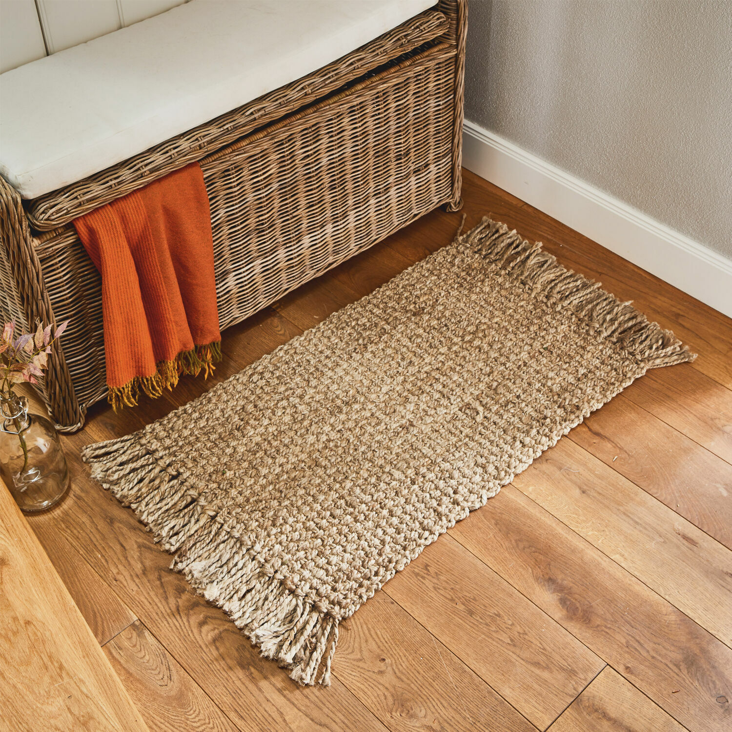 Stuoino Moody Tappeto beige con frange in materiale naturale su pavimento in legno in ambiente accogliente