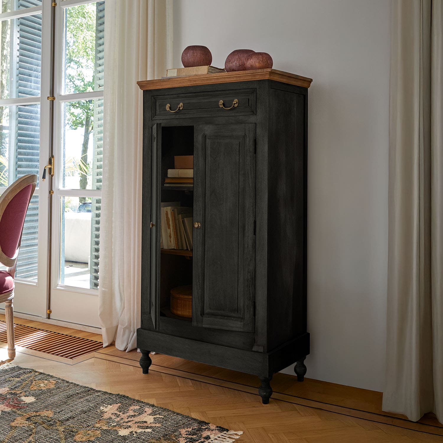 Mobile nero in legno con piano chiaro e maniglie in ottone in soggiorno classico