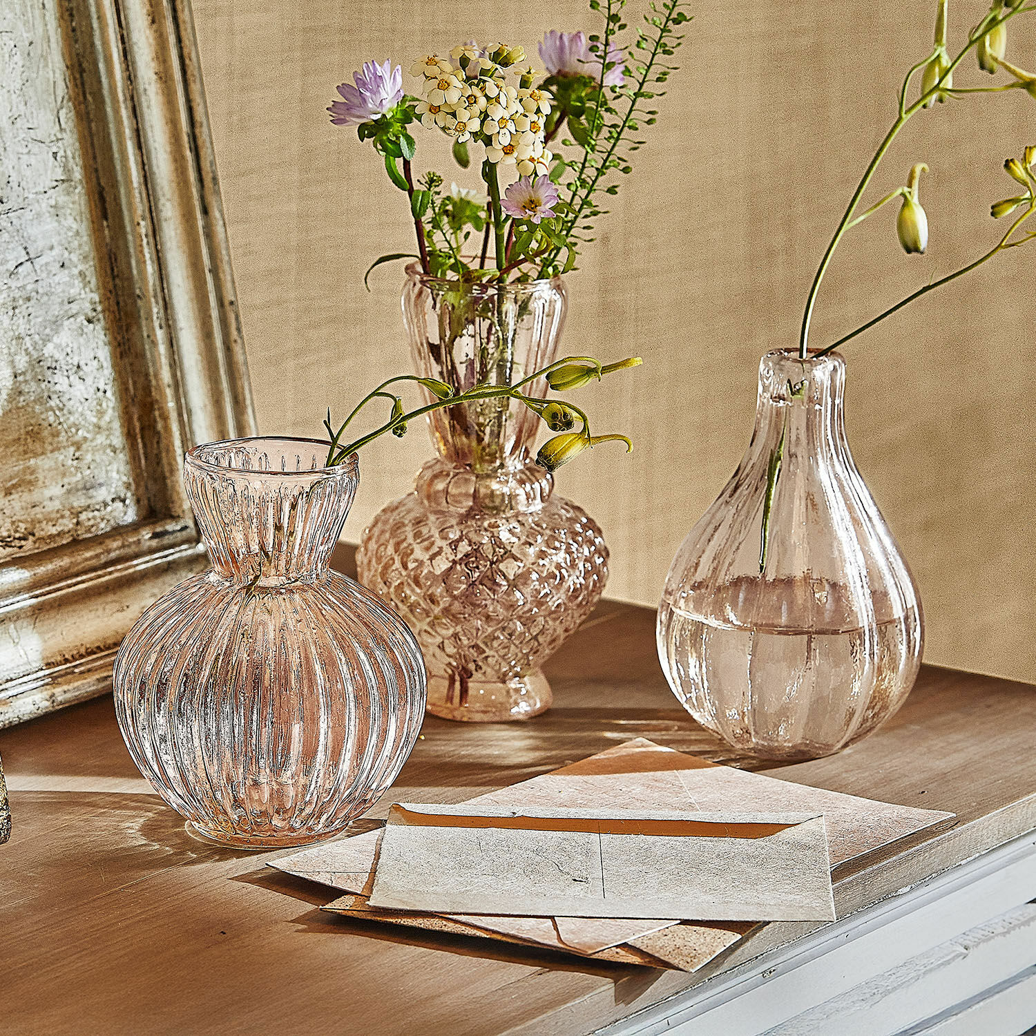 Set di 3 vasi Faunelle Tre vasi in vetro trasparente con fiori su un tavolo in legno in stile vintage