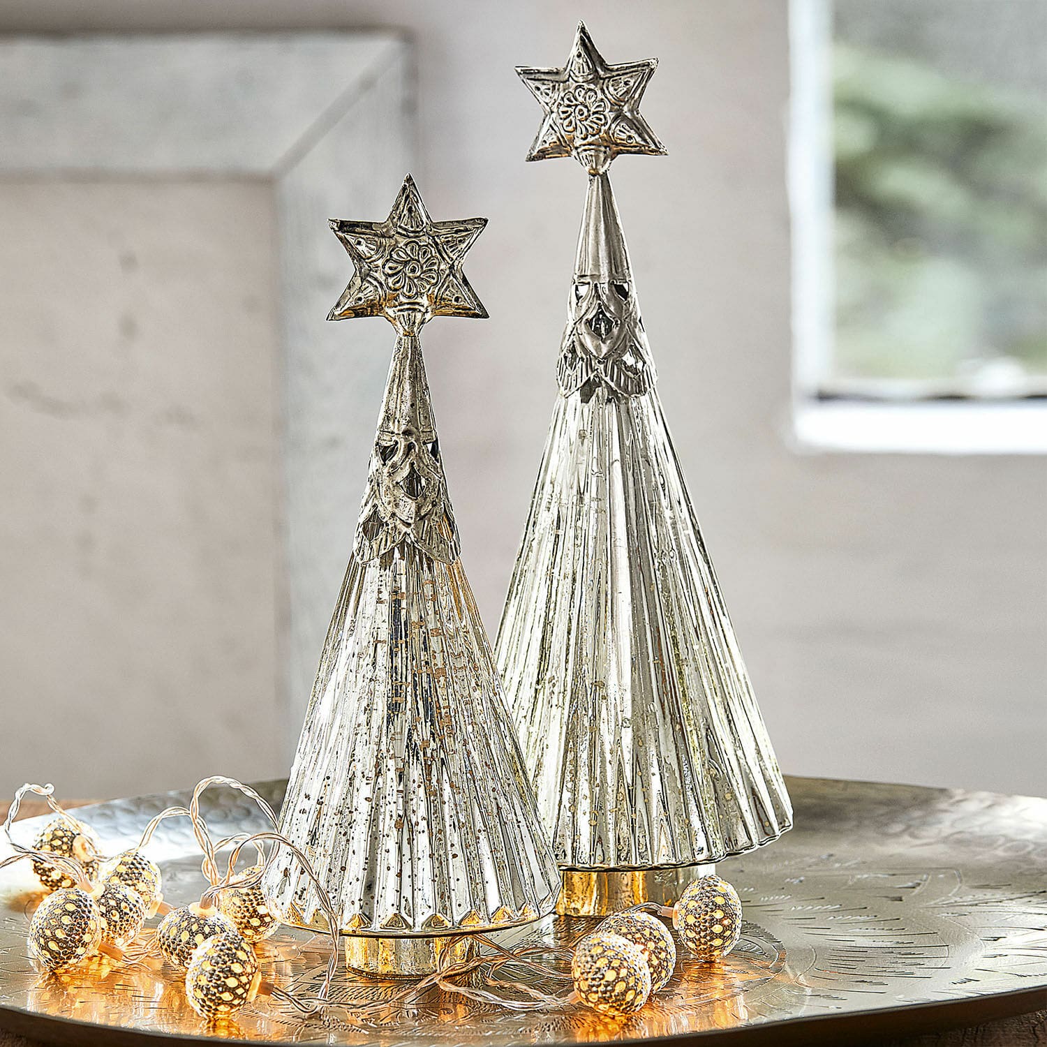Coppia di alberelli di Natale Lillemor Due alberi di Natale decorativi in metallo argentato con stelle in cima su tavolo festivo con luci LED