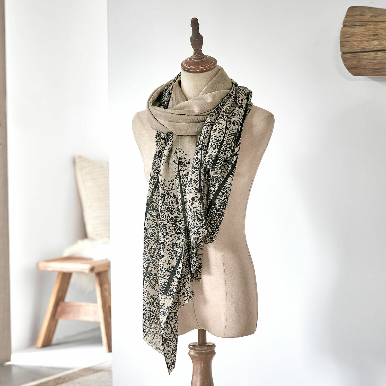 Scialle Daralon Sciarpa beige con motivo vegetale nero su manichino in ambiente luminoso, accessorio leggero e alla moda