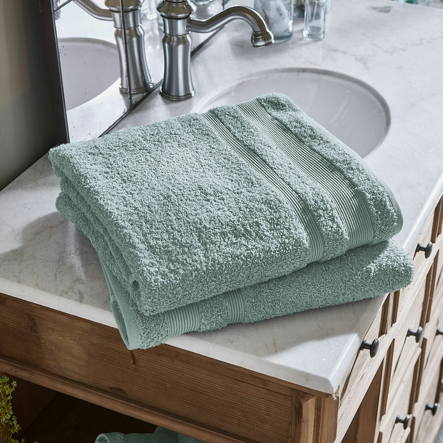 Coppia di teli da bagno Bourogne Morbidi asciugamani verdi in cotone su lavabo in marmo con mobile in legno in bagno