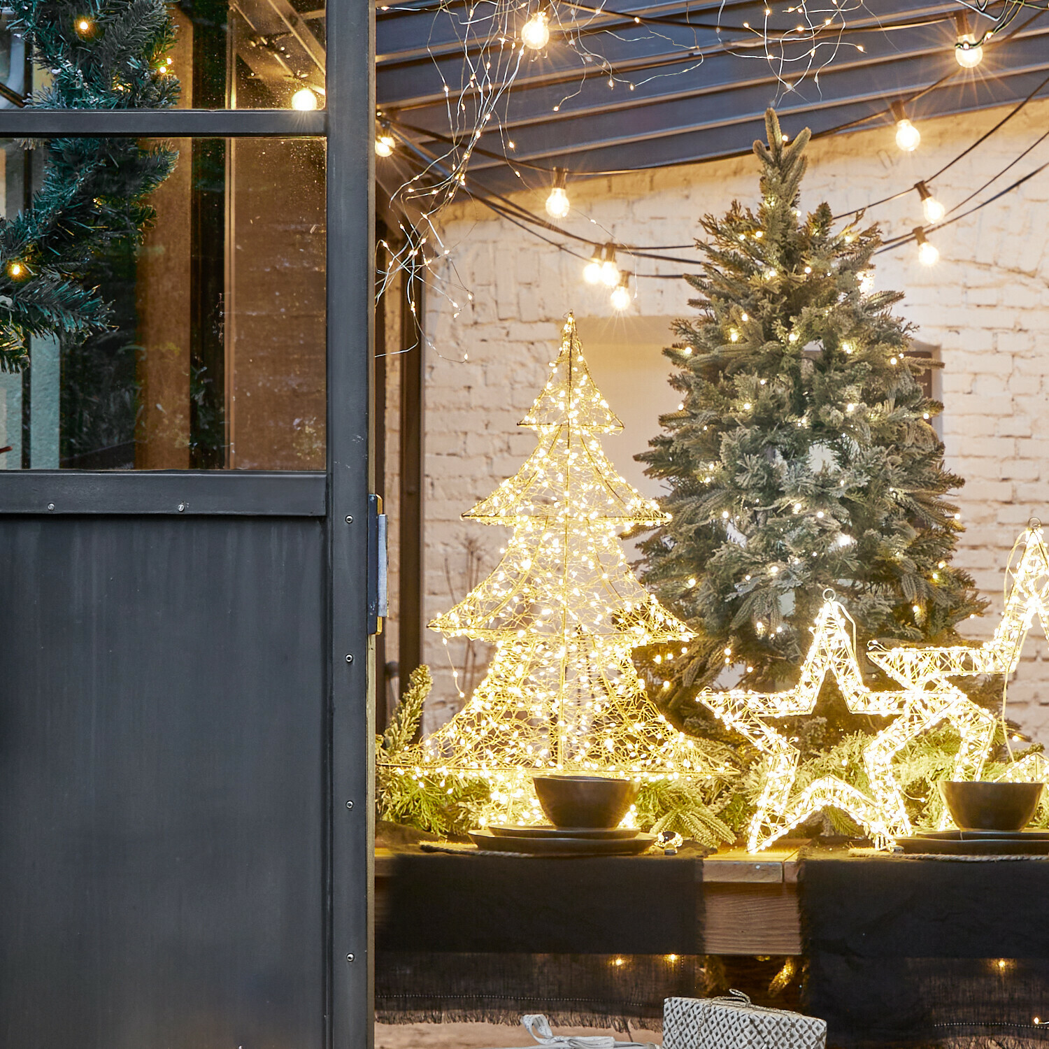 Alberello con luci a LED Vivetelle Decorazioni natalizie LED a forma di albero e stella su tavolo in legno con rami verdi