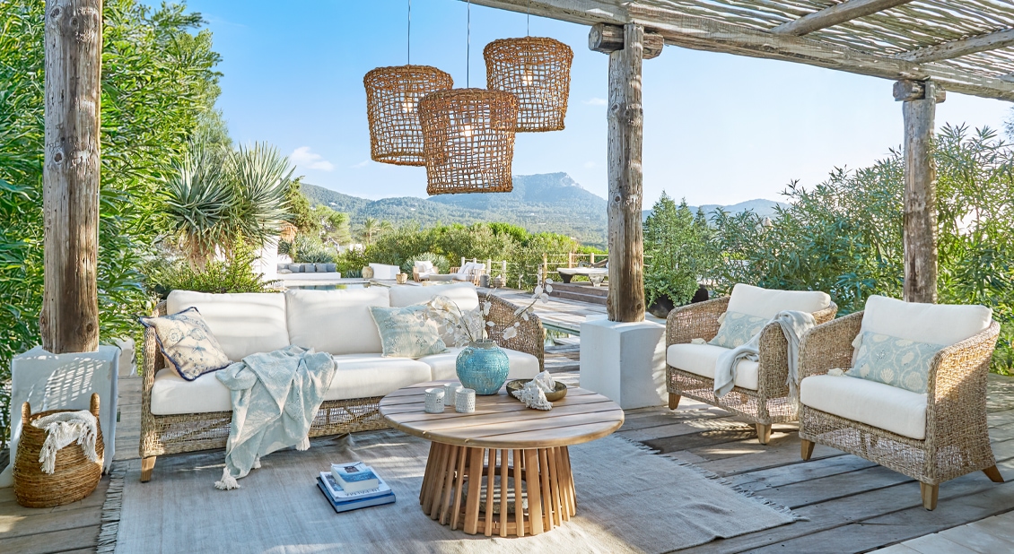 Set di mobili da giardino in rattan naturale con cuscini bianchi e tavolo rotondo in legno