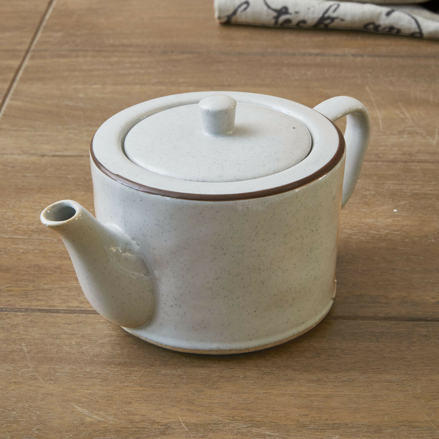 Teiera Biarré Teiera in ceramica bianca con bordo marrone su tavolo in legno per preparare tè