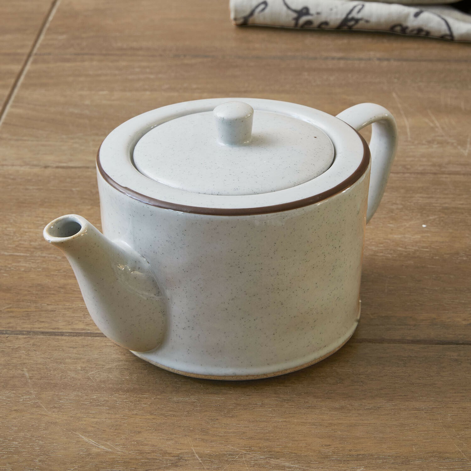 Teiera Biarré Teiera in ceramica bianca con bordo marrone su tavolo in legno per preparare tè