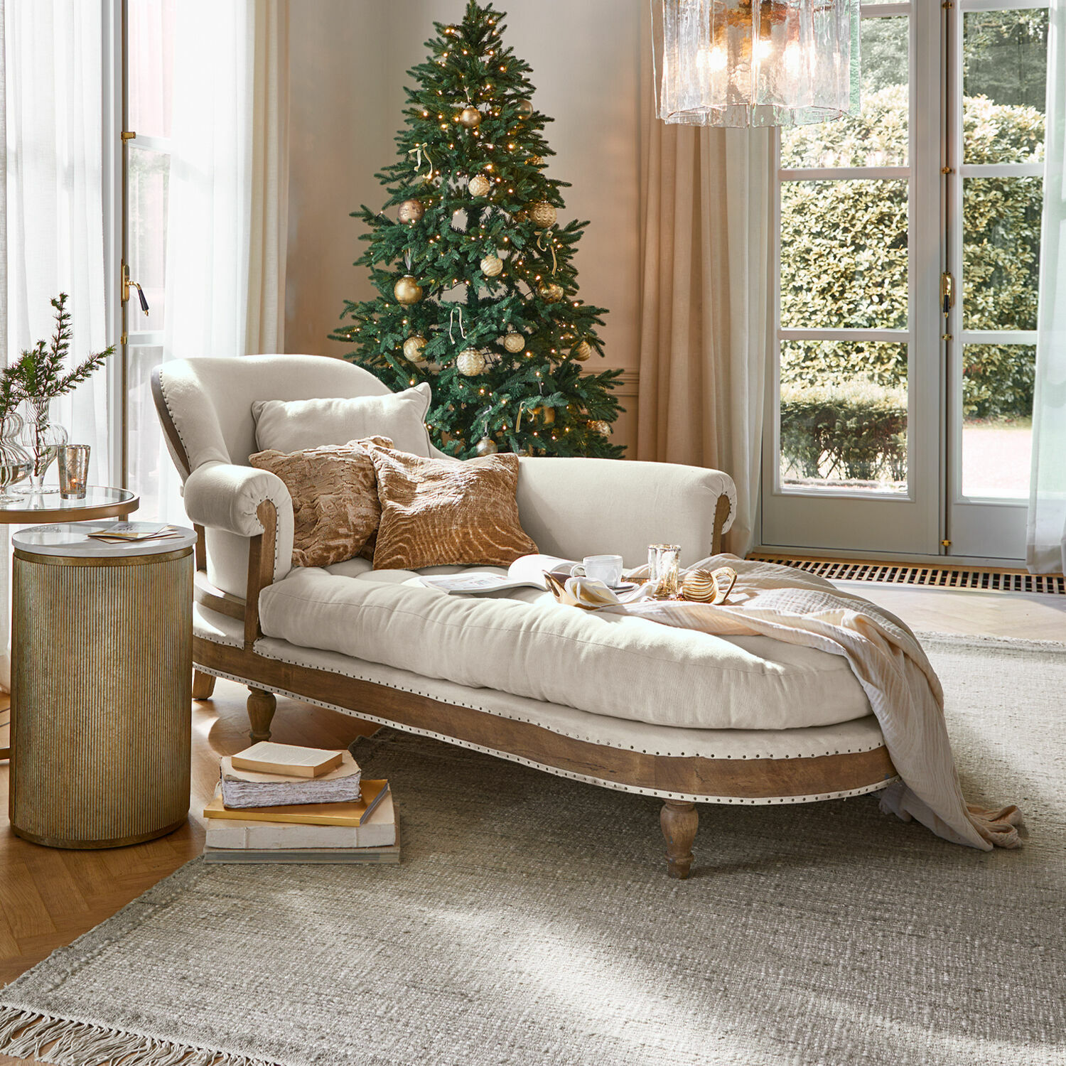 Chaise longue Queyranne Chaise longue beige con struttura in legno e cuscini morbidi in soggiorno accogliente con albero di Natale