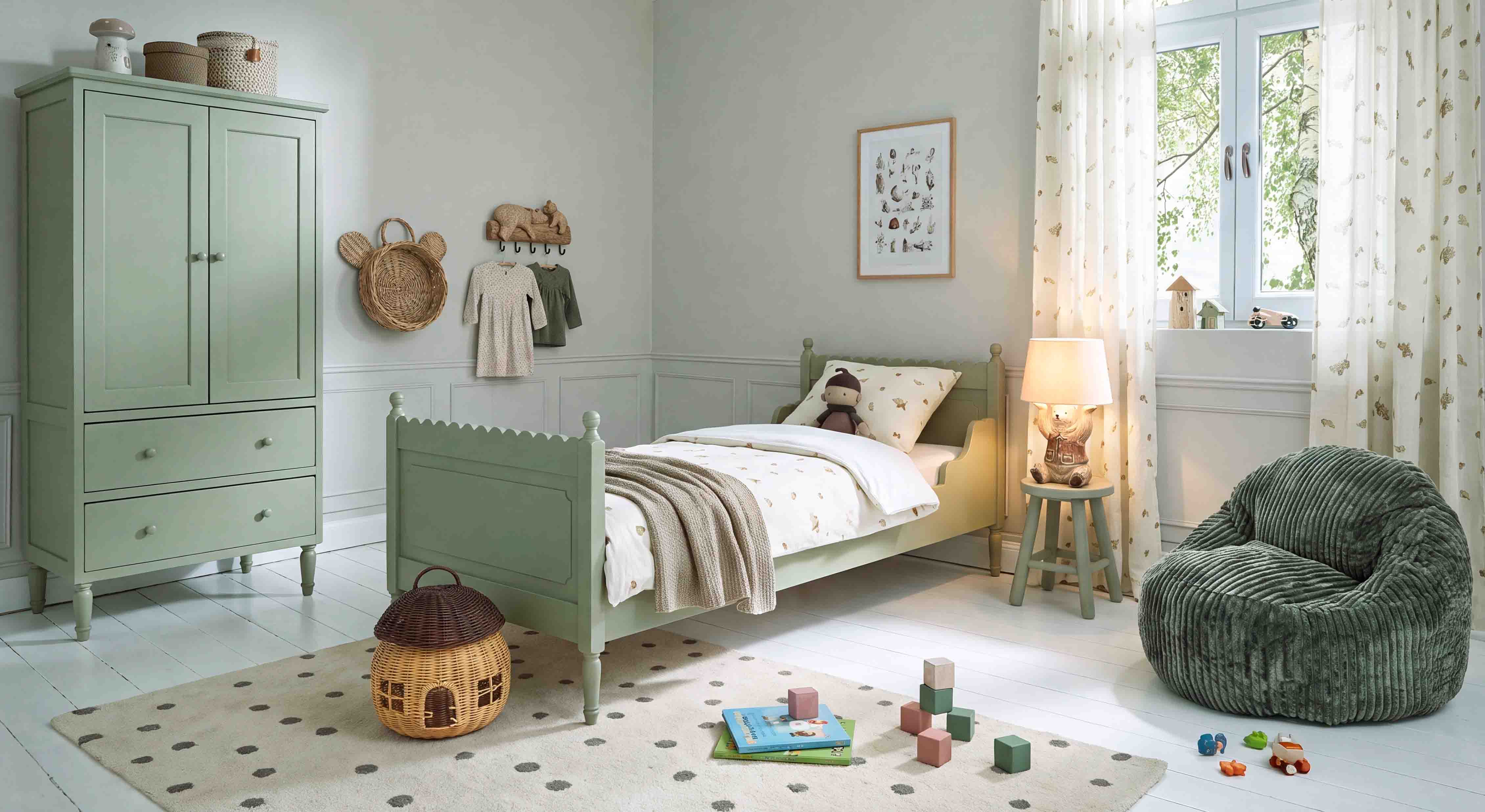 Armadio e letto in legno verde pastello in camera bambini con poltrona morbida e giocattoli