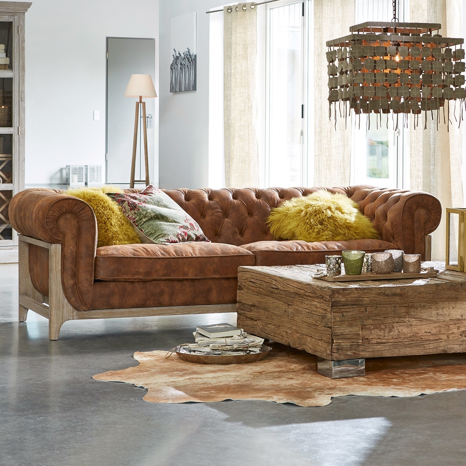 Divano Swansboro Divano Chesterfield in pelle marrone con struttura in legno e cuscini gialli in soggiorno moderno