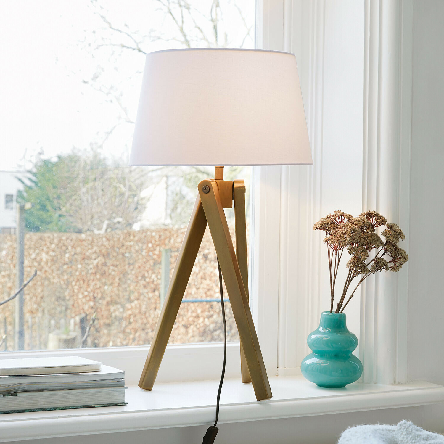 Lampada da tavolo Kelvio Lampada da tavolo con base in legno e paralume bianco su davanzale con vaso turchese