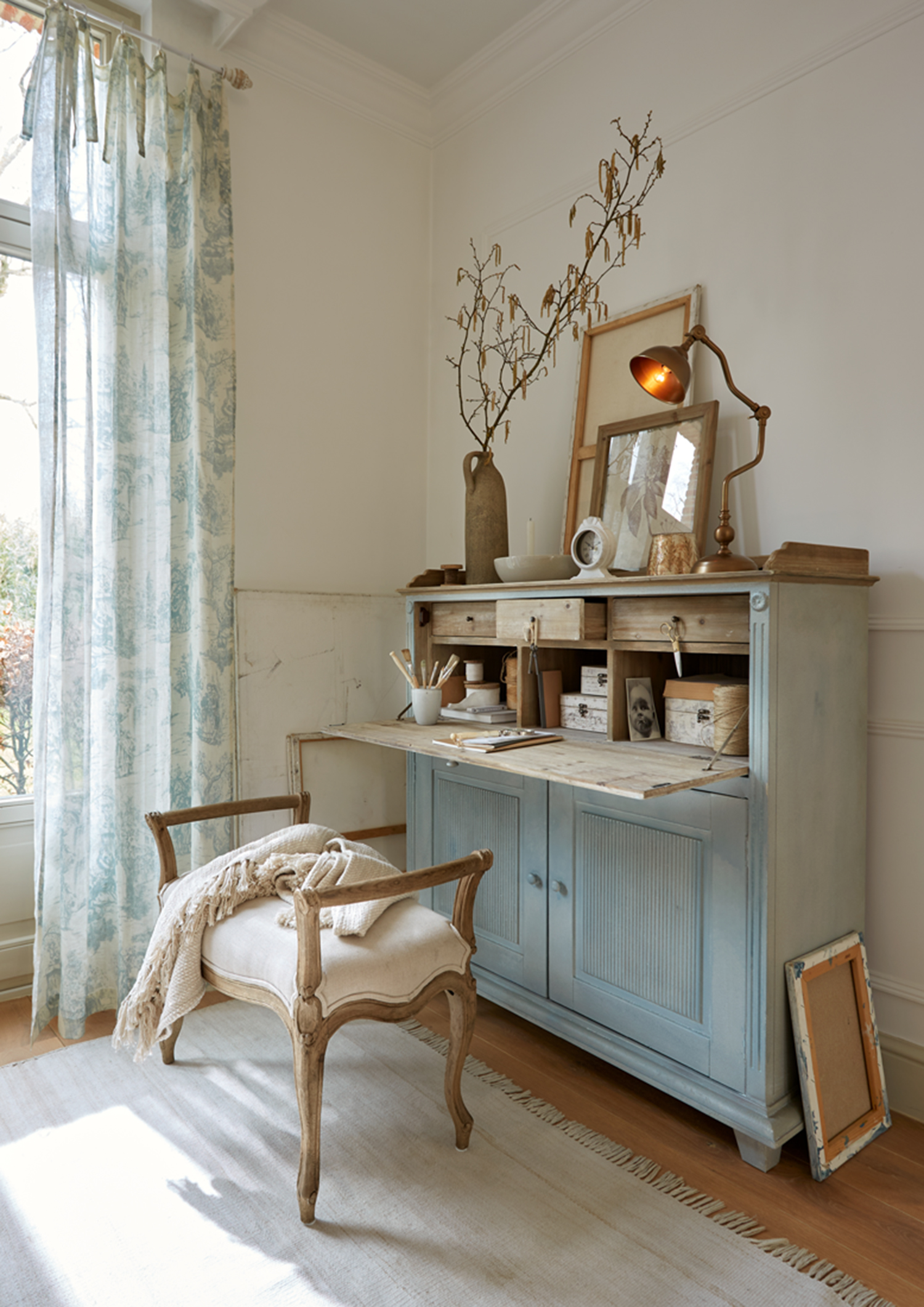 Credenza in legno blu con piano ribaltabile e decorazioni in ambiente luminoso e accogliente
