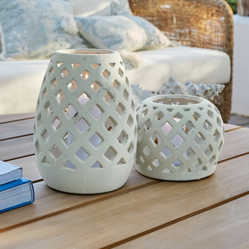 Due lanterne bianche in ceramica con motivo traforato su tavolo in legno, decorazione da giardino