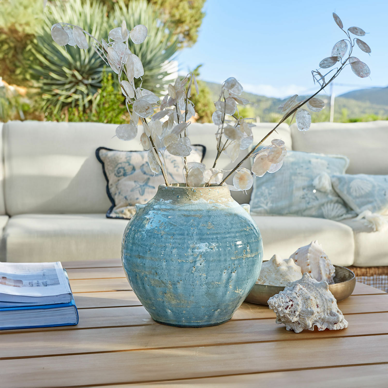 Vaso Trevigno Vaso in ceramica blu con rami secchi decorativi su tavolo in legno in soggiorno