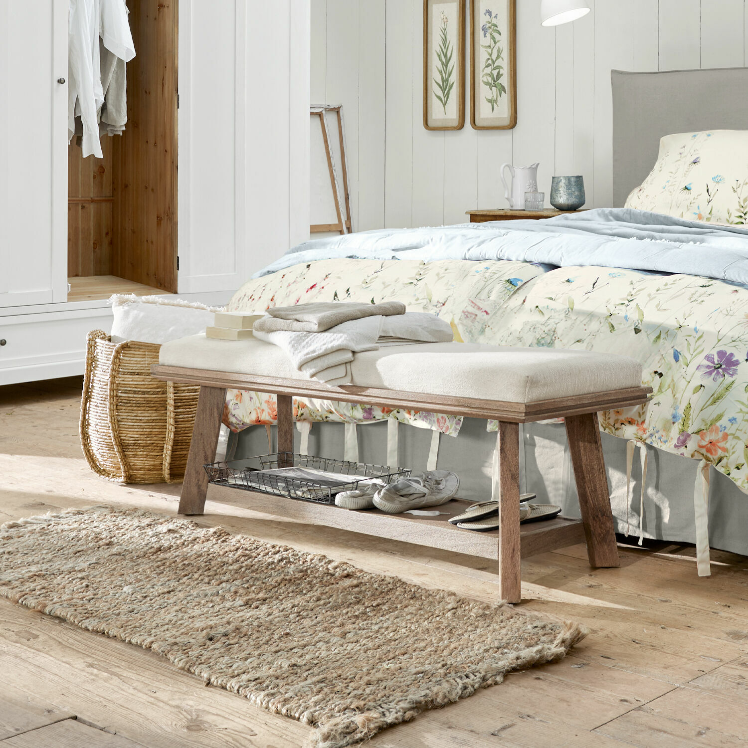 Panca Abington Panca in legno con seduta imbottita chiara in camera da letto, tappeto naturale e decorazioni floreali