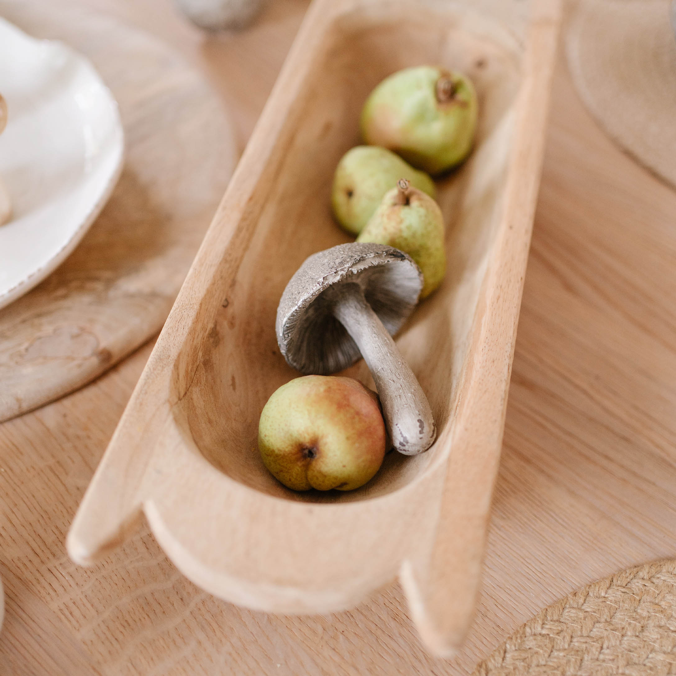 Ciotola in legno con fungo decorativo e pere verdi per tavola autunnale