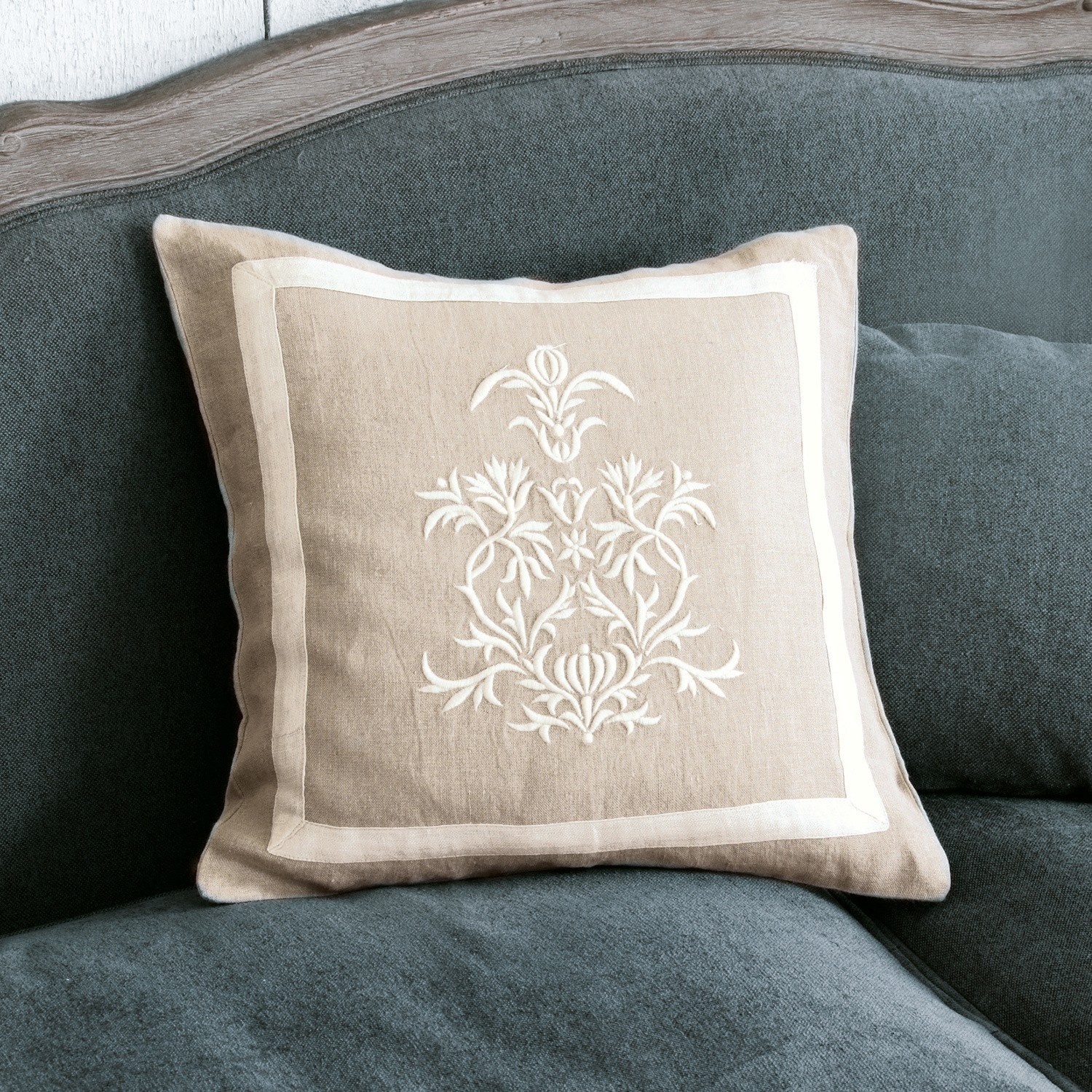 Copricuscino Many Cuscino beige in lino con ricamo bianco su divano grigio, elemento decorativo per interni