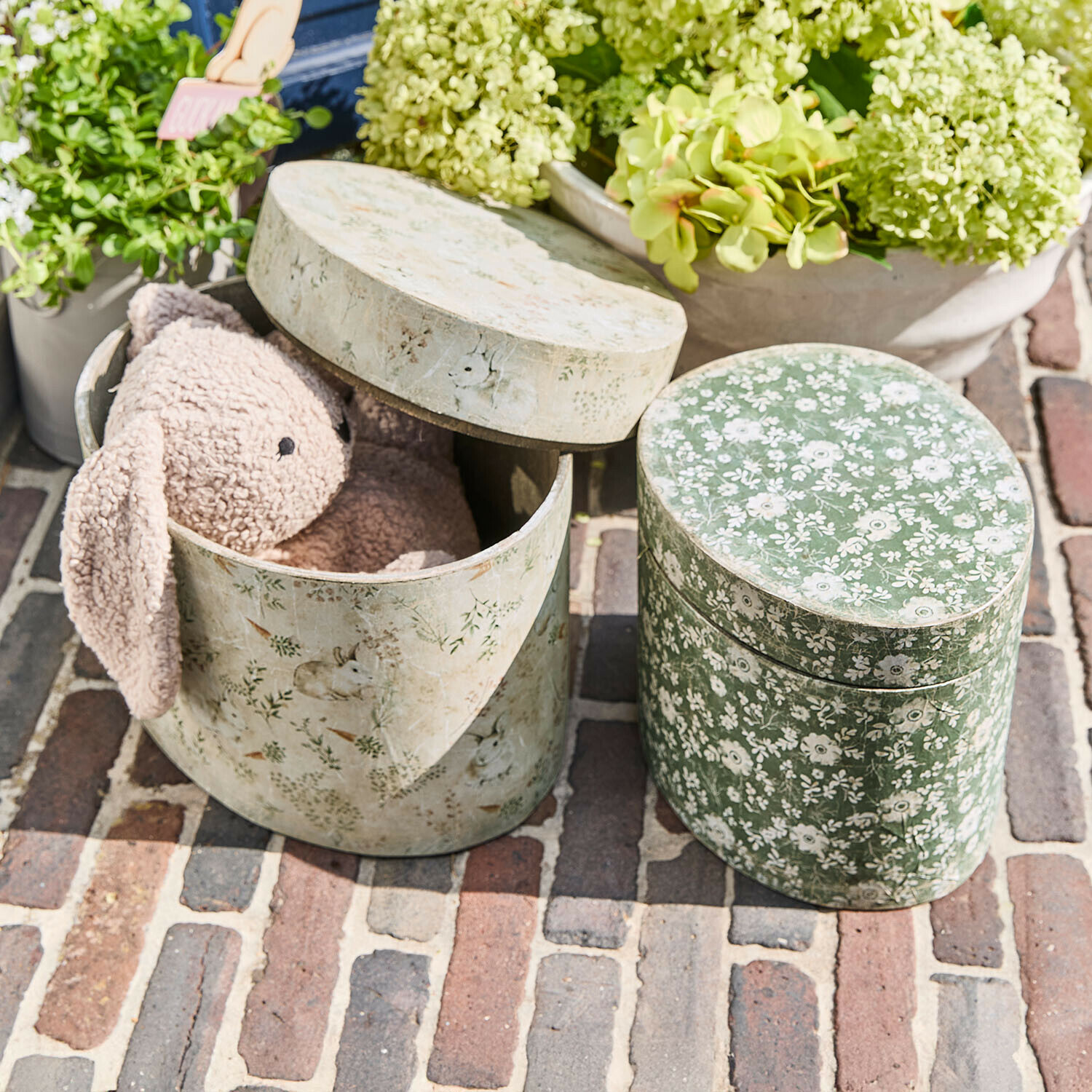 Coppia di scatole Puddlebrook Scatole ovali decorative con motivi floreali e coniglietti, una con coniglio di peluche rosa all'interno