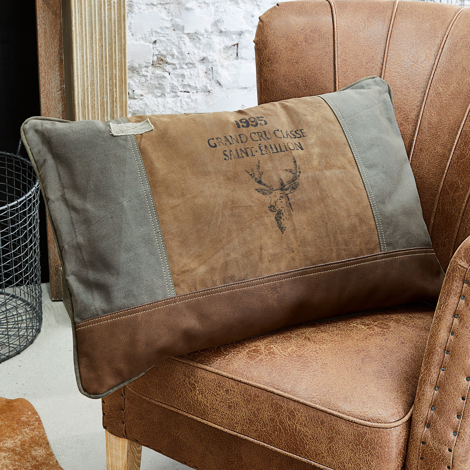 Cuscino Chiron Cuscino decorativo marrone e grigio con motivo cervo su poltrona in pelle marrone stile vintage