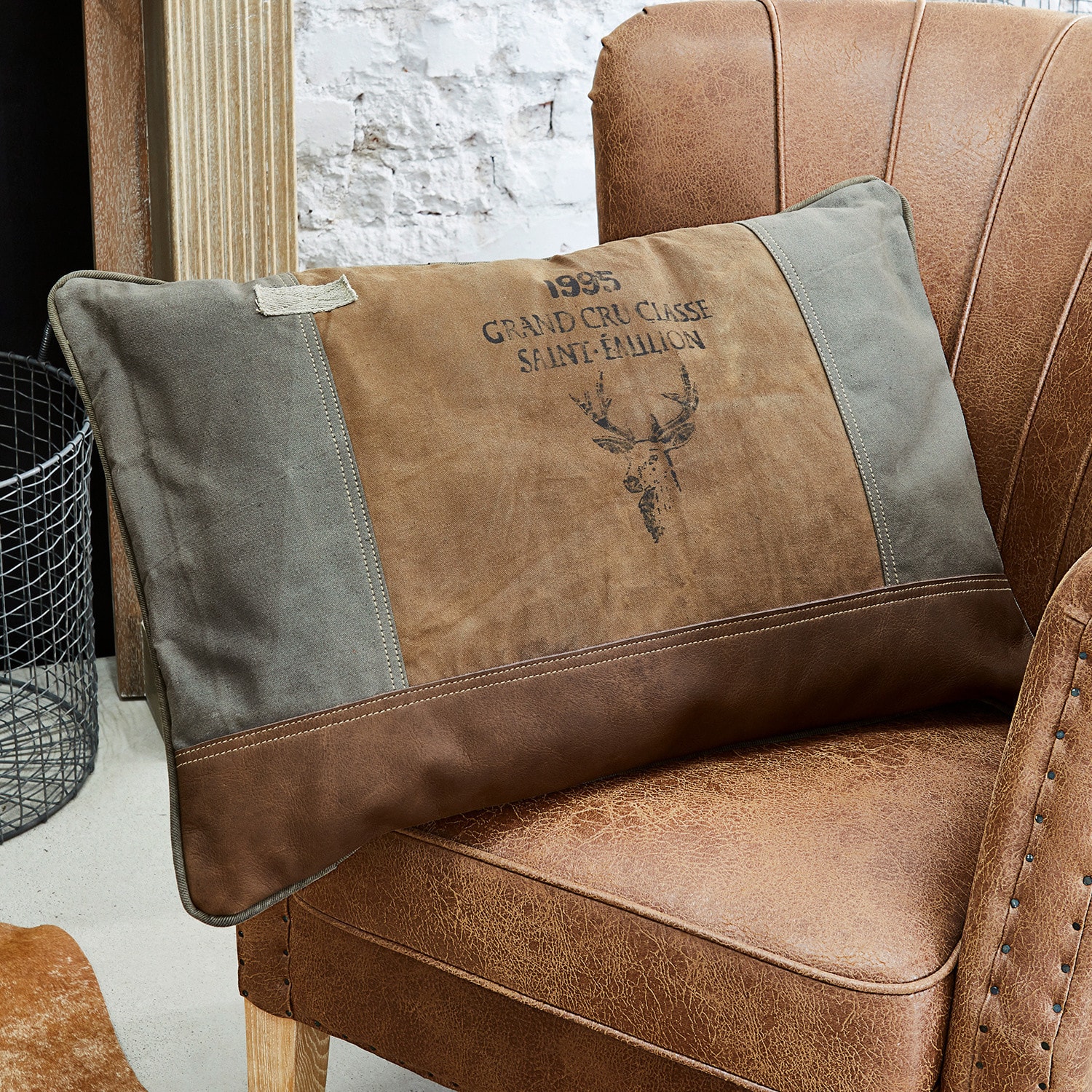 Cuscino Chiron Cuscino decorativo marrone e grigio con motivo cervo su poltrona in pelle marrone stile vintage